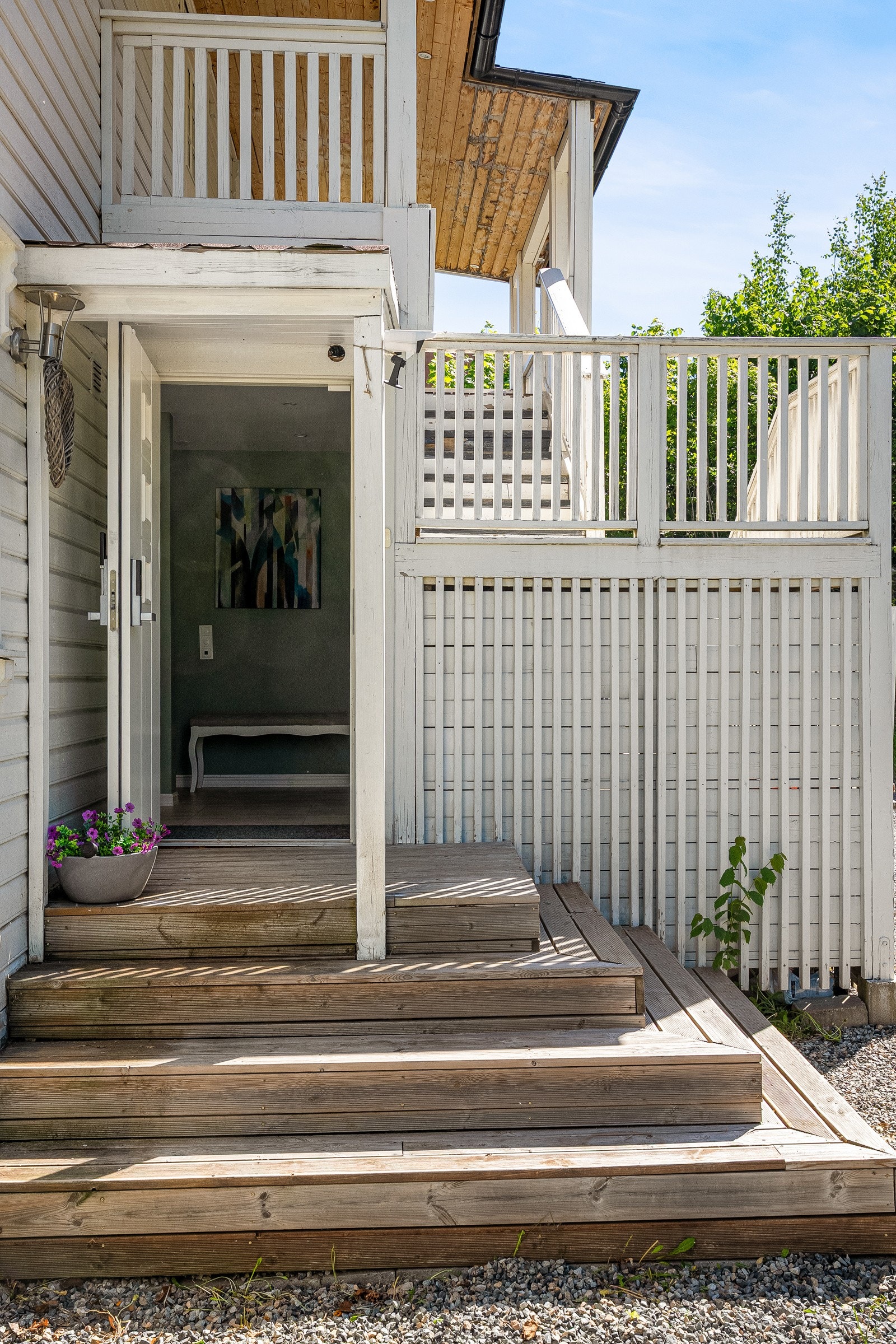 Boligens inngangsparti i første etasje nås via en pen tretrapp fra gruset gårdsplass. Galleribilde