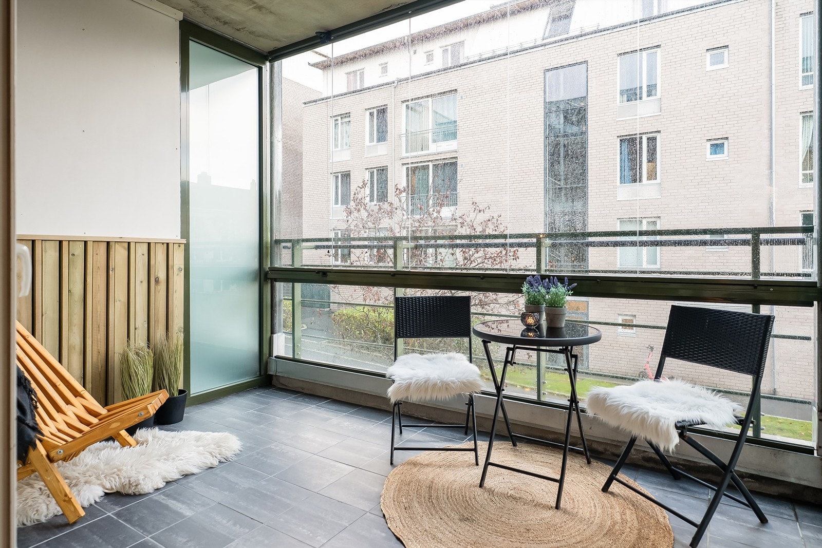 Romslig innglasset balkong med flisbelagt gulv og nye panelbord på vegg Galleribilde