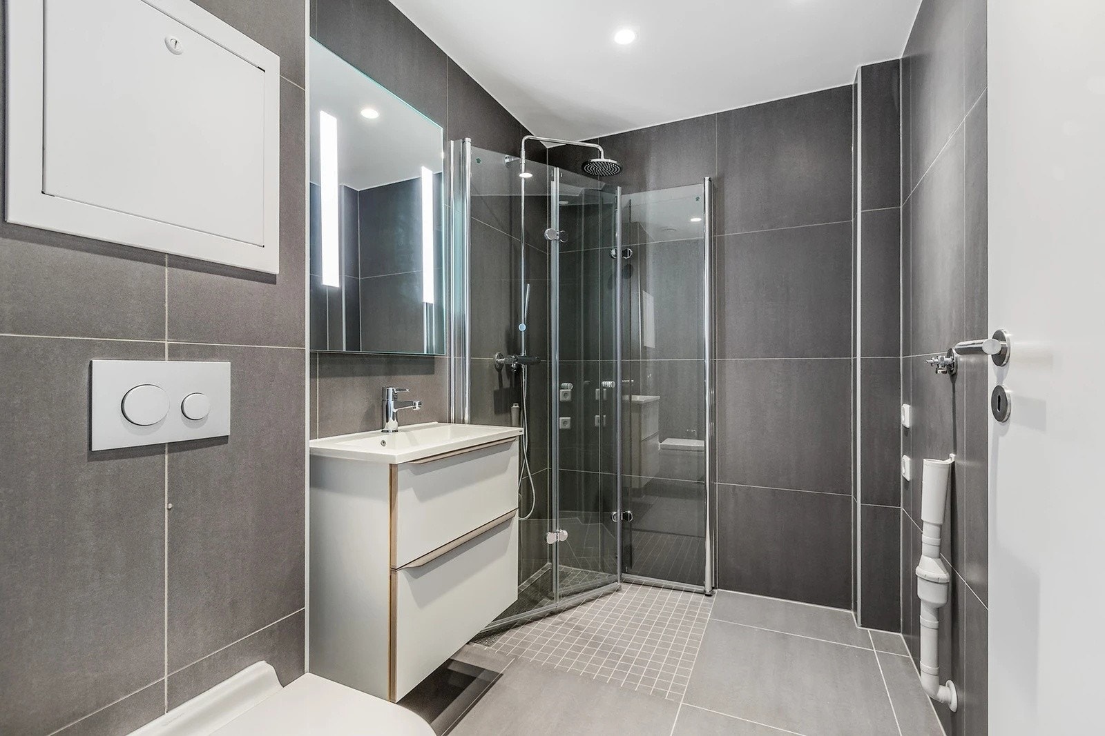 Stilrent og lekkert baderom fra 2019 med elektriske varmekabler, downlights i himlingen, avtrekk via balansert ventilasjon og opplegg for vaskemaskin. Galleribilde