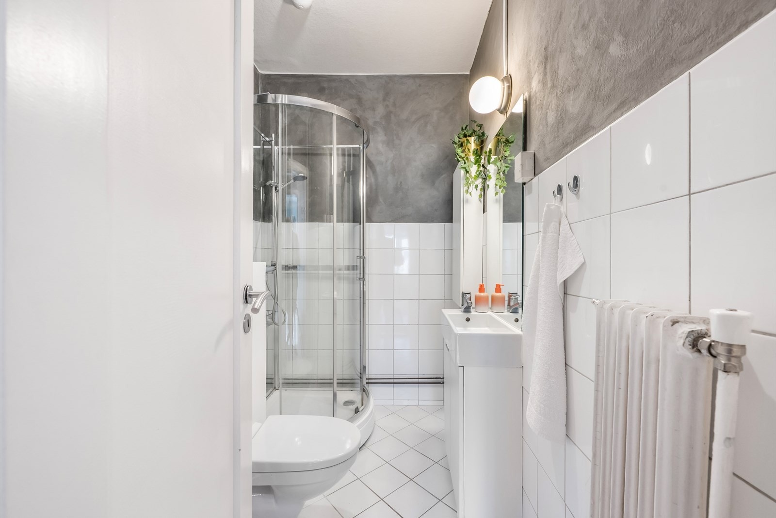 Badet har fliser på gulvet, og en kombinasjon av fliser og malte, slette flater på veggene. Galleribilde