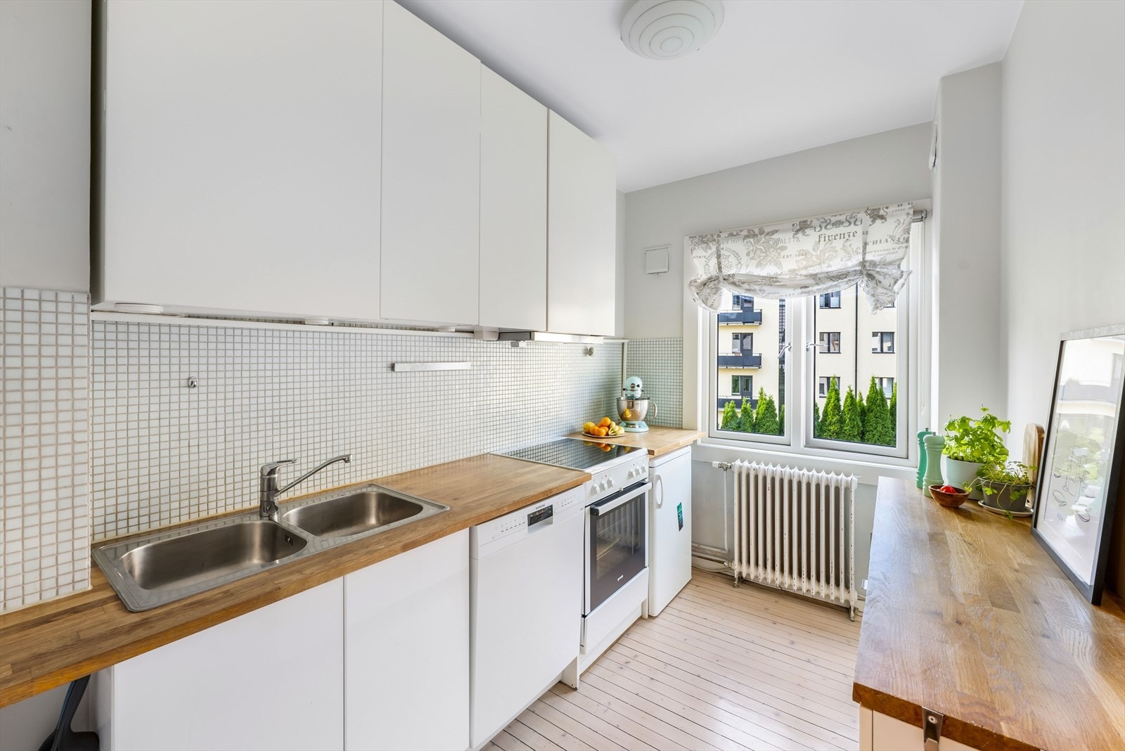 Kjøkkenet har hvite fronter og benkeplate i tre. Det er godt med skap- og benkeplass. Galleribilde