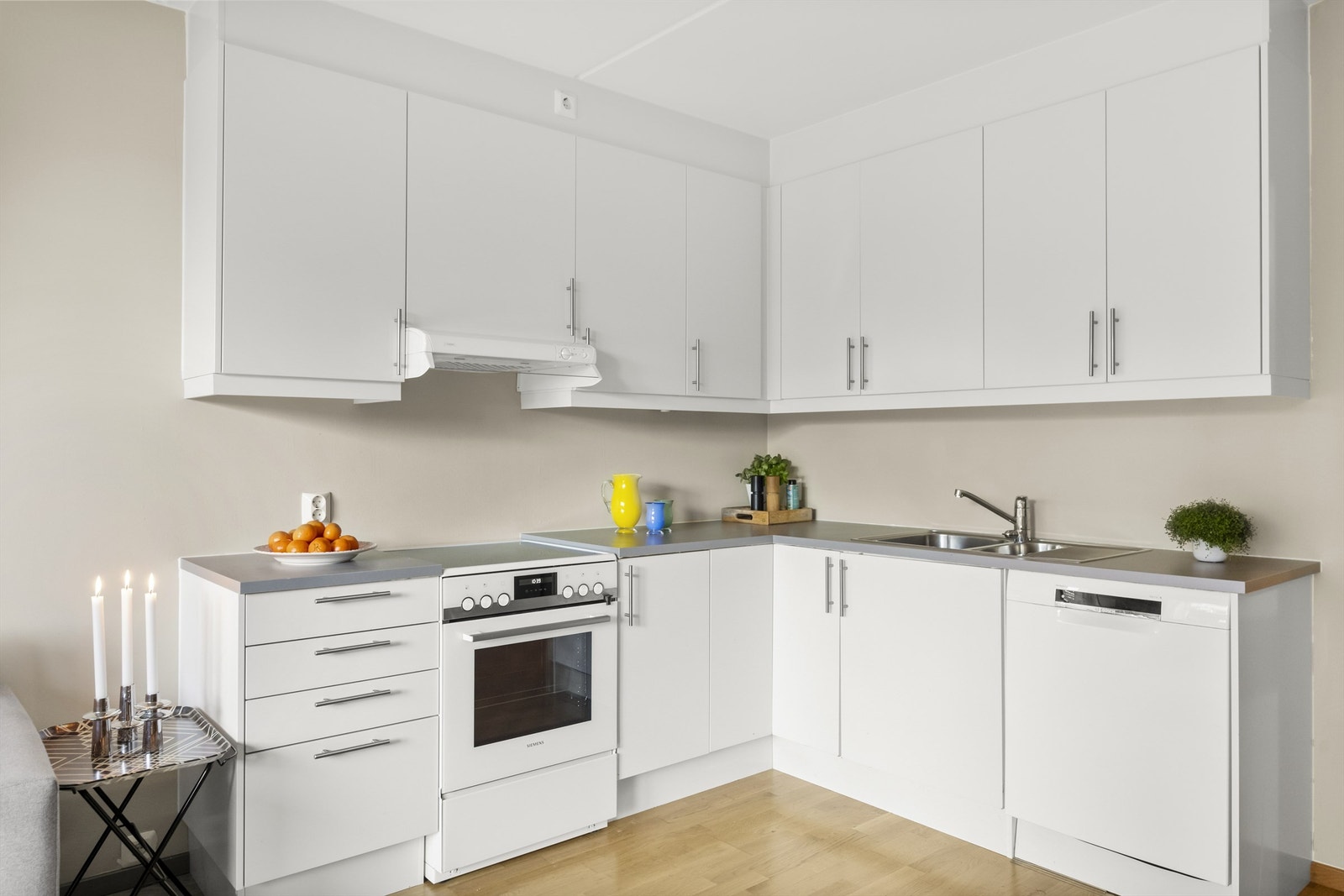 Nøytral kjøkkeninnredning med glatte fronter. Mekanisk avtrekk på kjøkken. Galleribilde