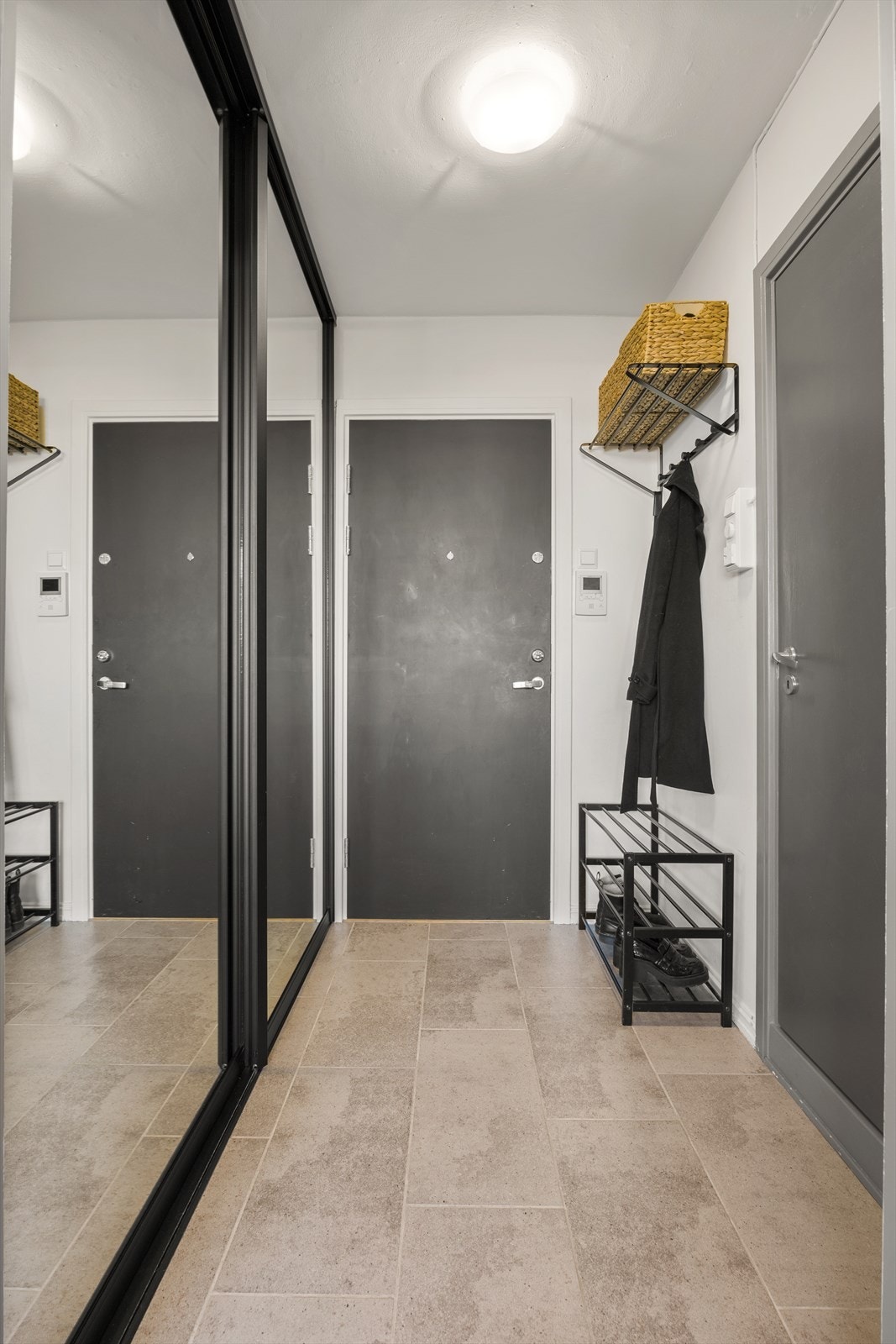 Man ønskes velkommen inn i en romslig entré med plass til å sette skoene og henge yttertøyet i stor garderobe. Leiligheten er tilknyttet felles dørcalling. Galleribilde