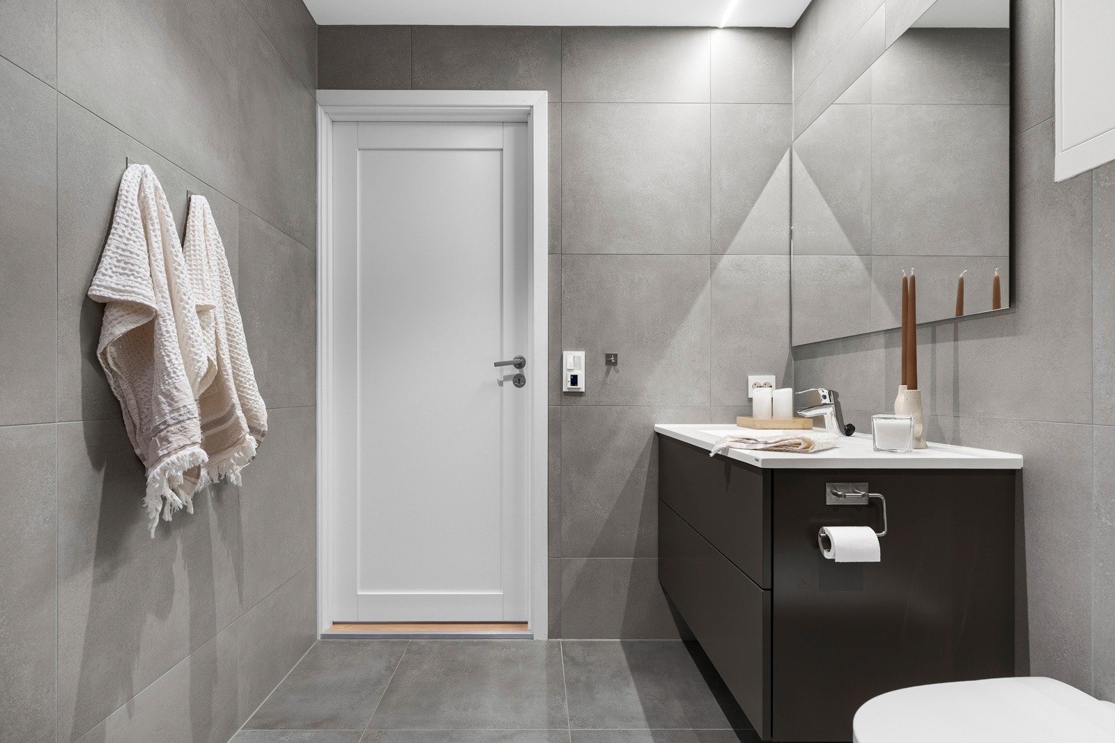 Innredningen inkluderer nedfelt servant, veggmontert toalett og dusjvegger/hjørne. Det er også slukrenne i dusjsonen. Galleribilde