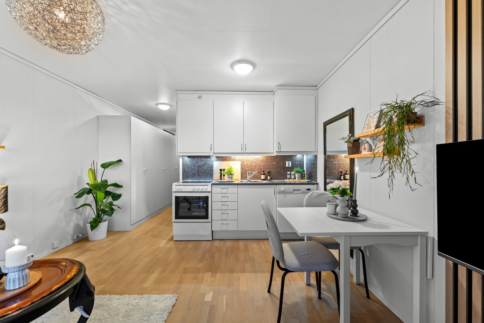 Kjøkkenet er praktisk og stilrent utformet med innredning plassert langs én vegg, noe som gir en ryddig og effektiv løsning. Galleribilde