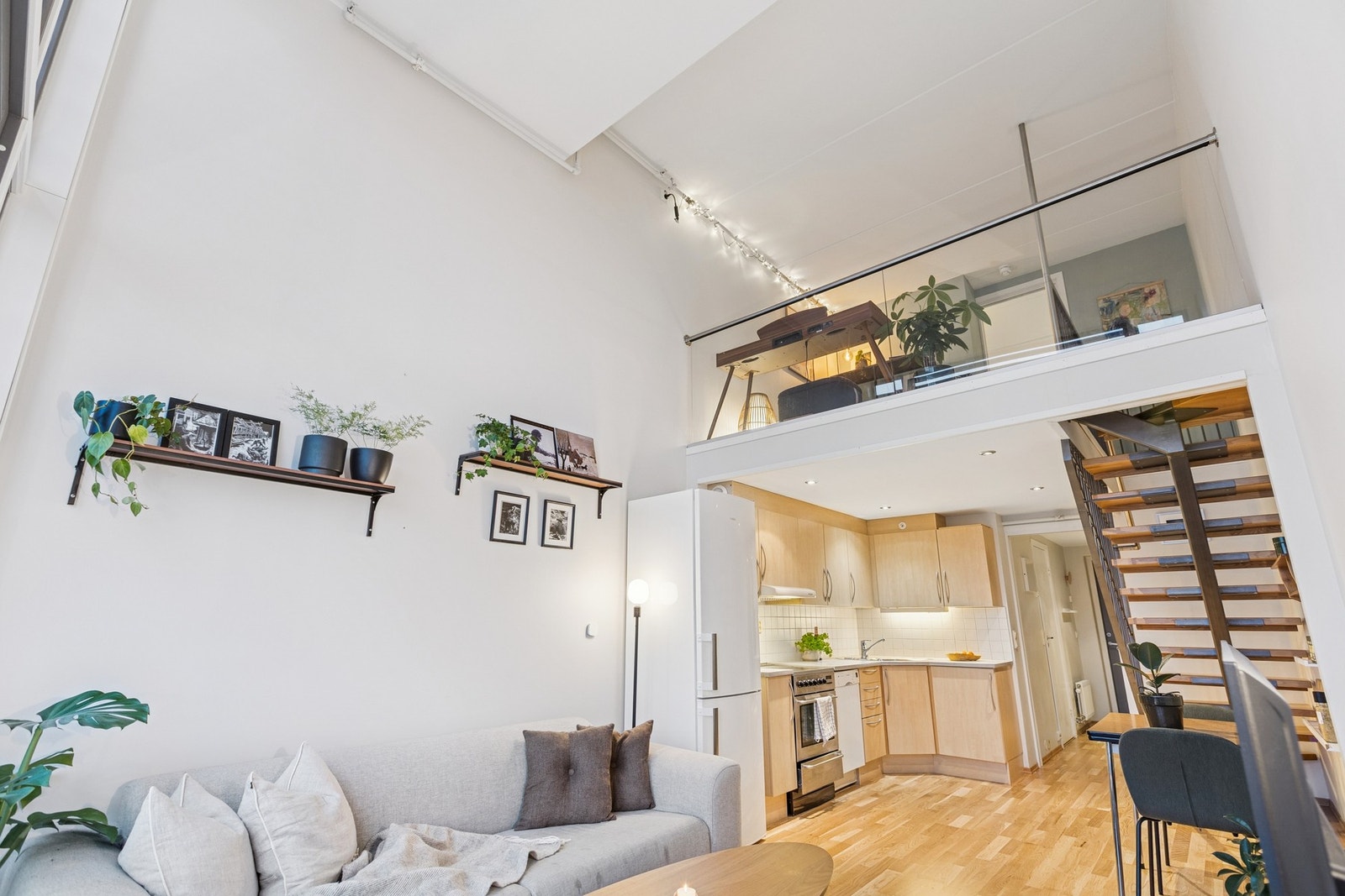 Leiligheten har en åpen og luftig stue med svært god takhøyde og gode vindusflater som slipper inn rikelig med naturlig lys Galleribilde