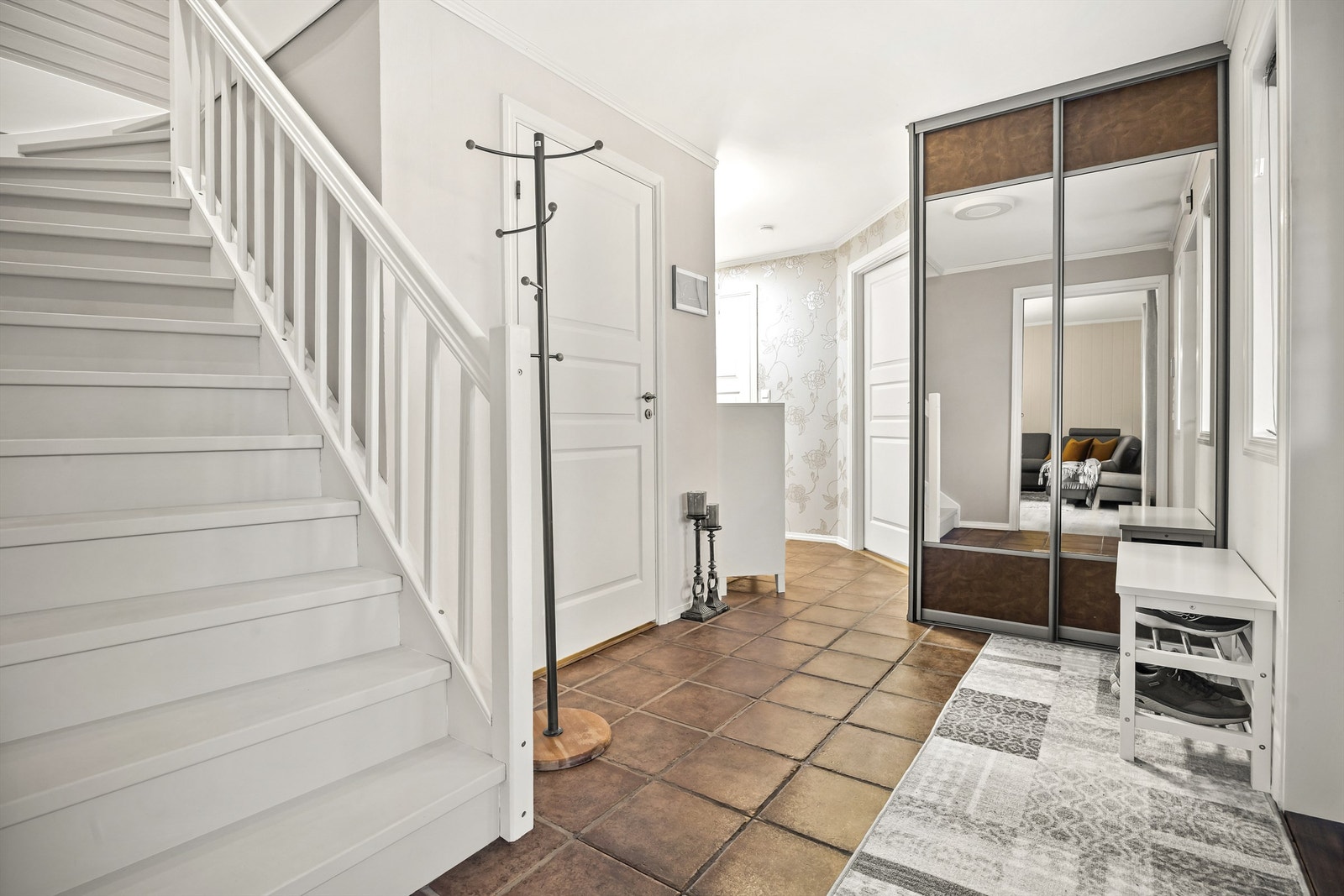 Entréen har flislagt gulv med gulvvarme og en praktisk skyvedørsgarderobe. Galleribilde