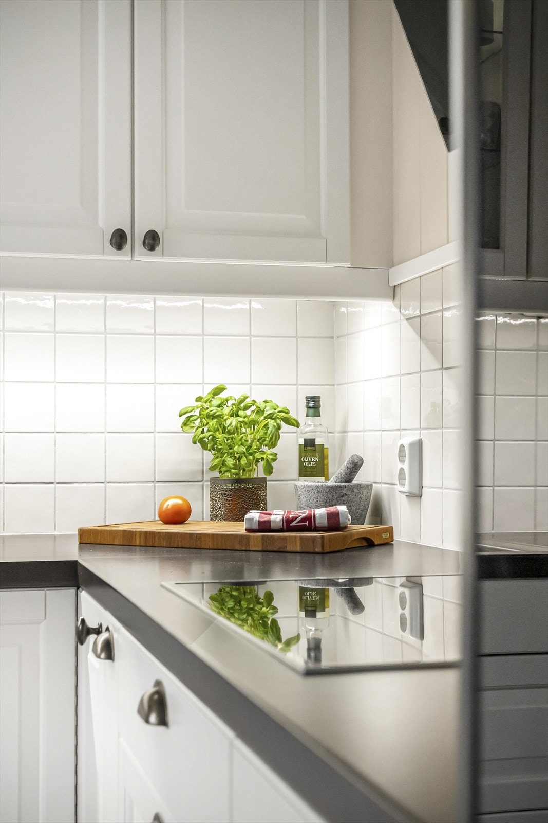 Kjøkkenet har integrerte hvitevarer, inkludert platetopp med komfyrvakt og stekeovn i høyskap. Galleribilde