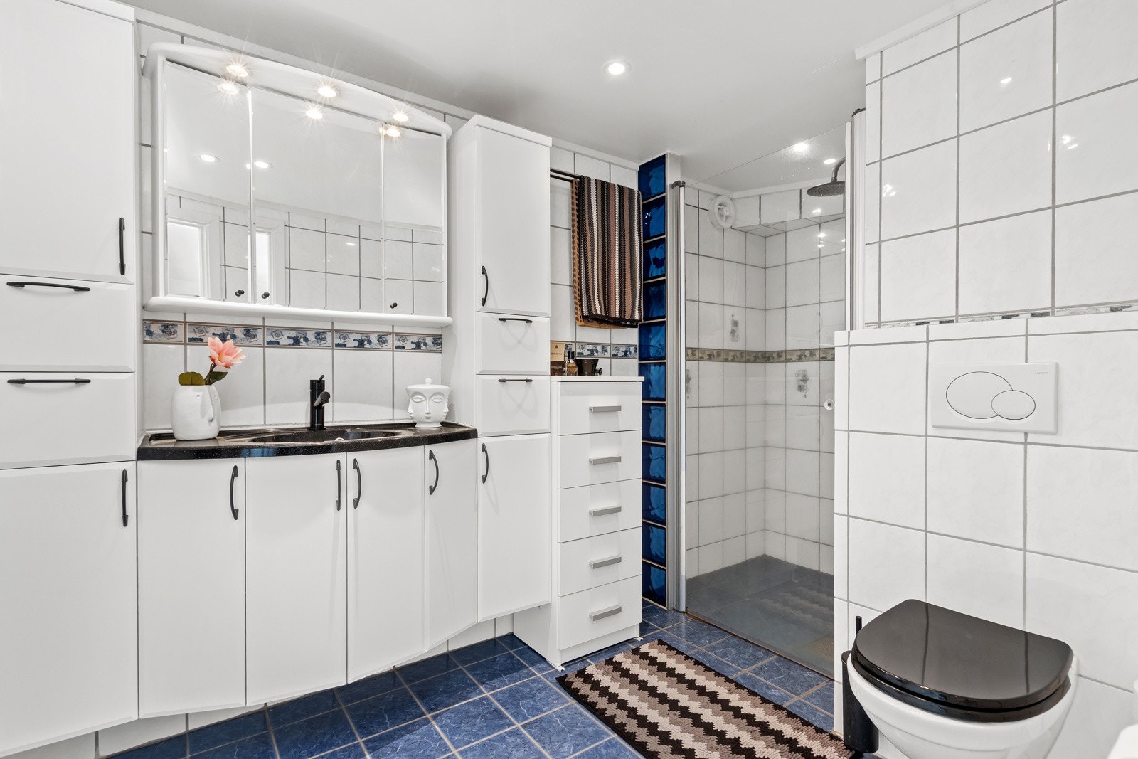 Flott, flislagt bad med varme i gulv, romslig baderomsinnredning, dusjnisje og vegghengt toalett. Galleribilde