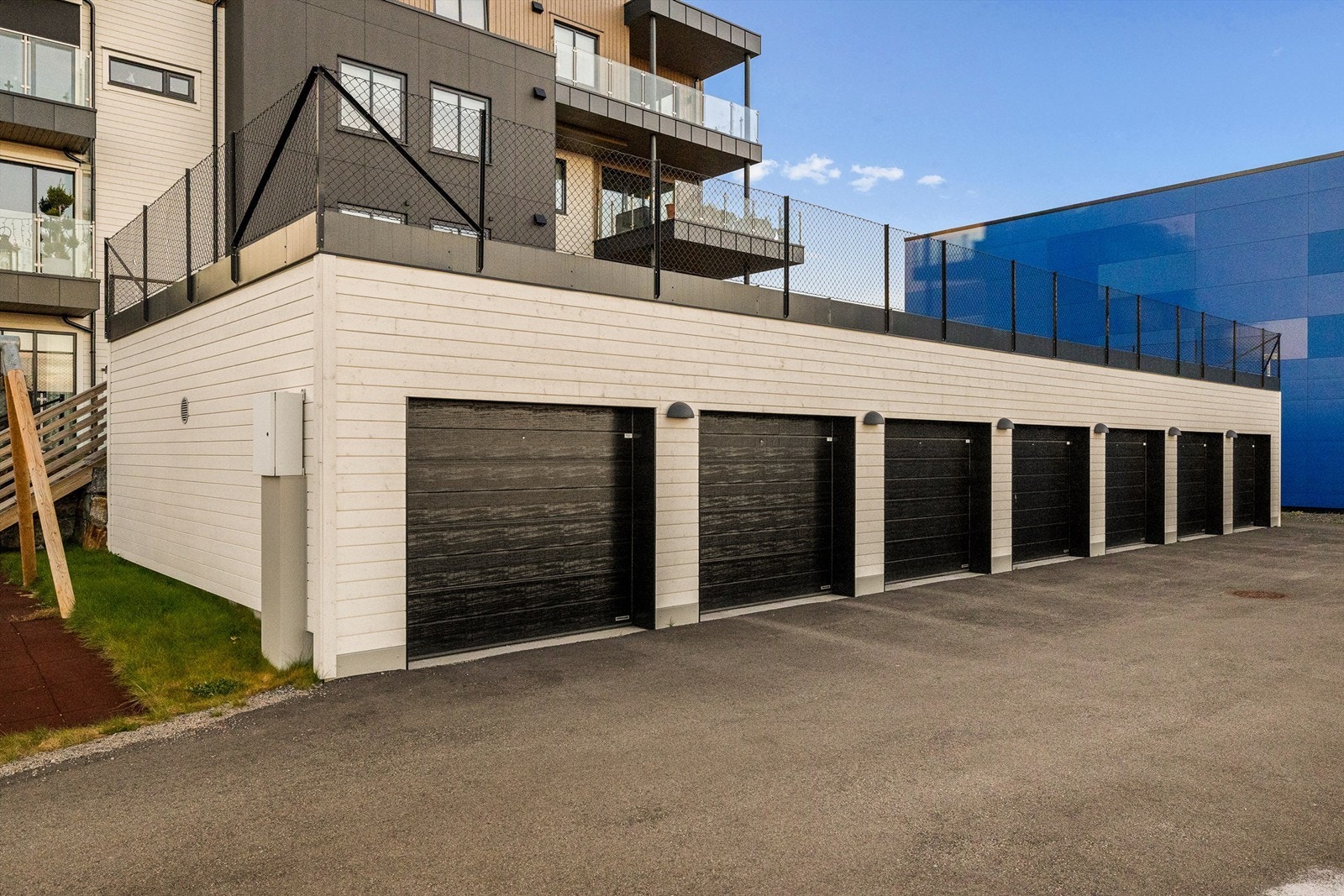 Garasjer i rekke med en plass til hver bolig. I tillegg er det gjesteparkering på tomten. Galleribilde