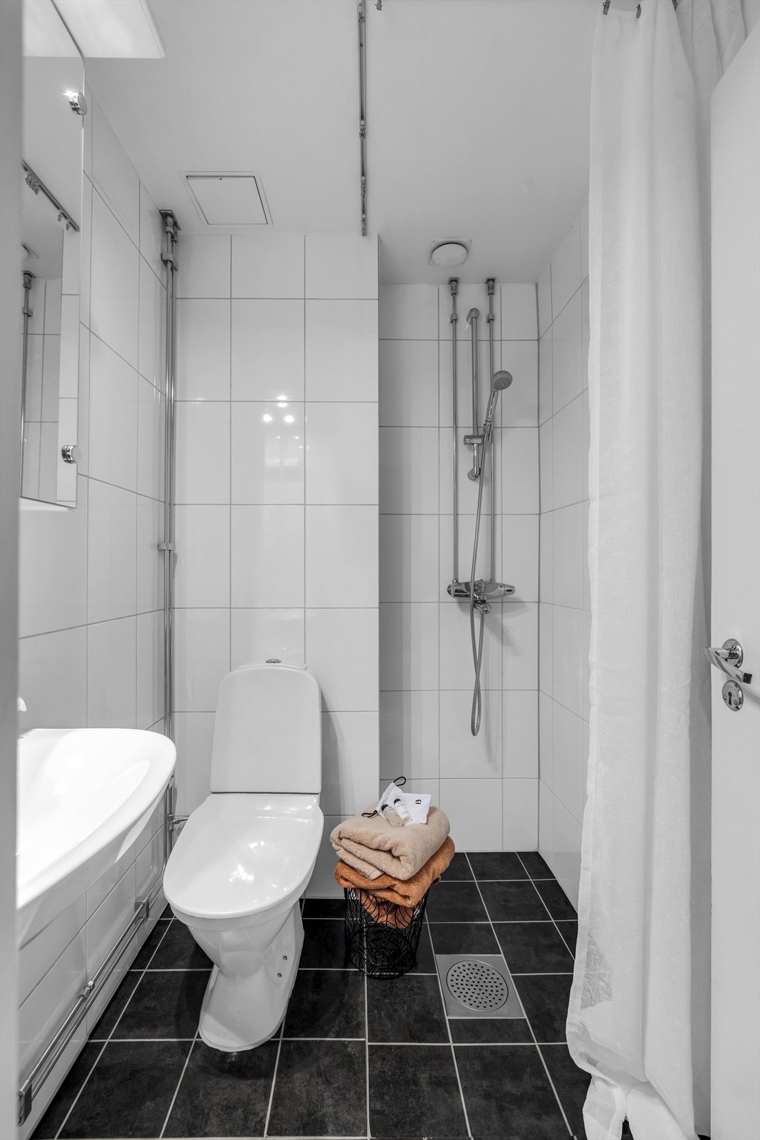 Pent, flislagt bad med servant, toalett og dusj. Galleribilde