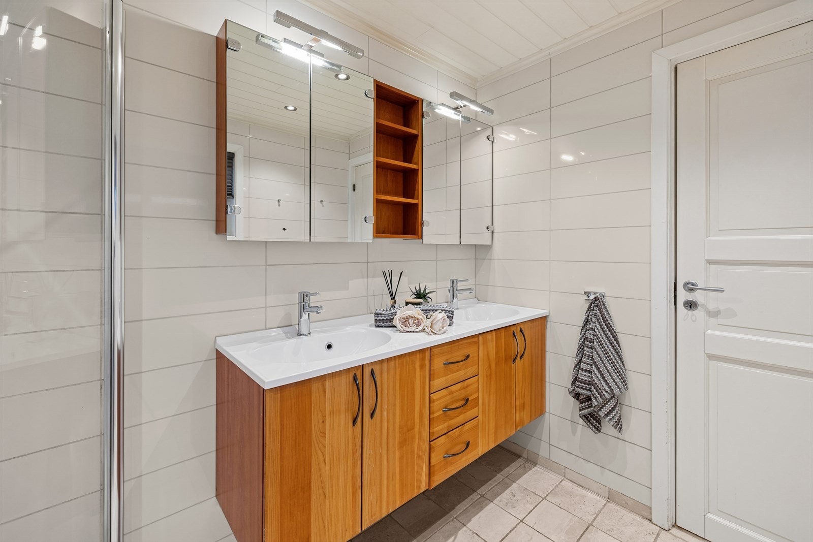 Badet i 1. etasje er tilbygget boligen og har fliser på vegger og gulv, samt panel i himlingen. Gulvet er utstyrt med elektriske varmekabler. Galleribilde