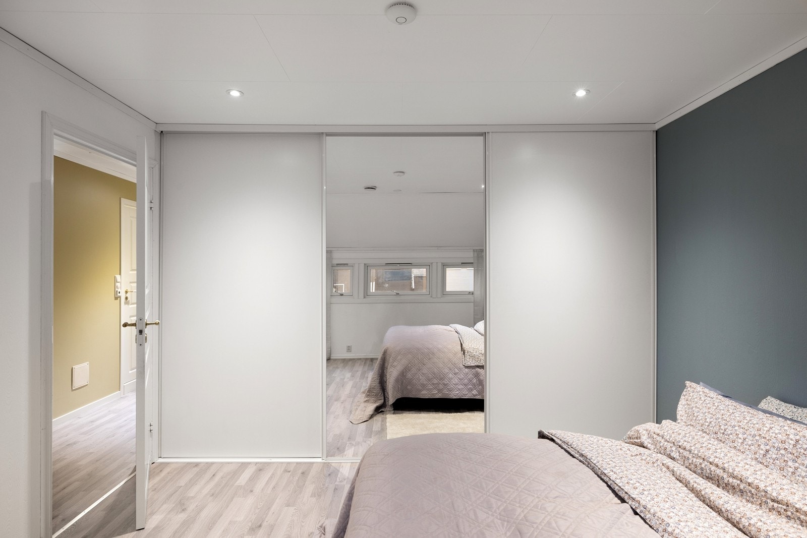 Skyvedørsgarderobe med speilfronter gir rikelig med oppbevaring og en god romfølelse. Galleribilde