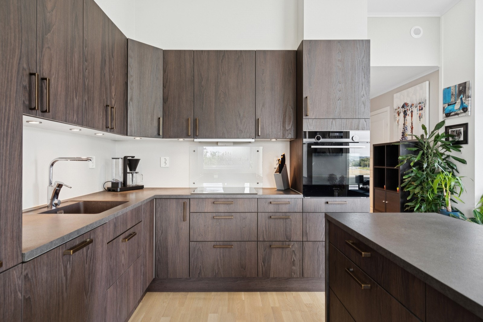 Lekkert kjøkken med en praktisk kjøkken-øy. Det er rikelig med skap- og benkplass på kjøkkenet. Galleribilde