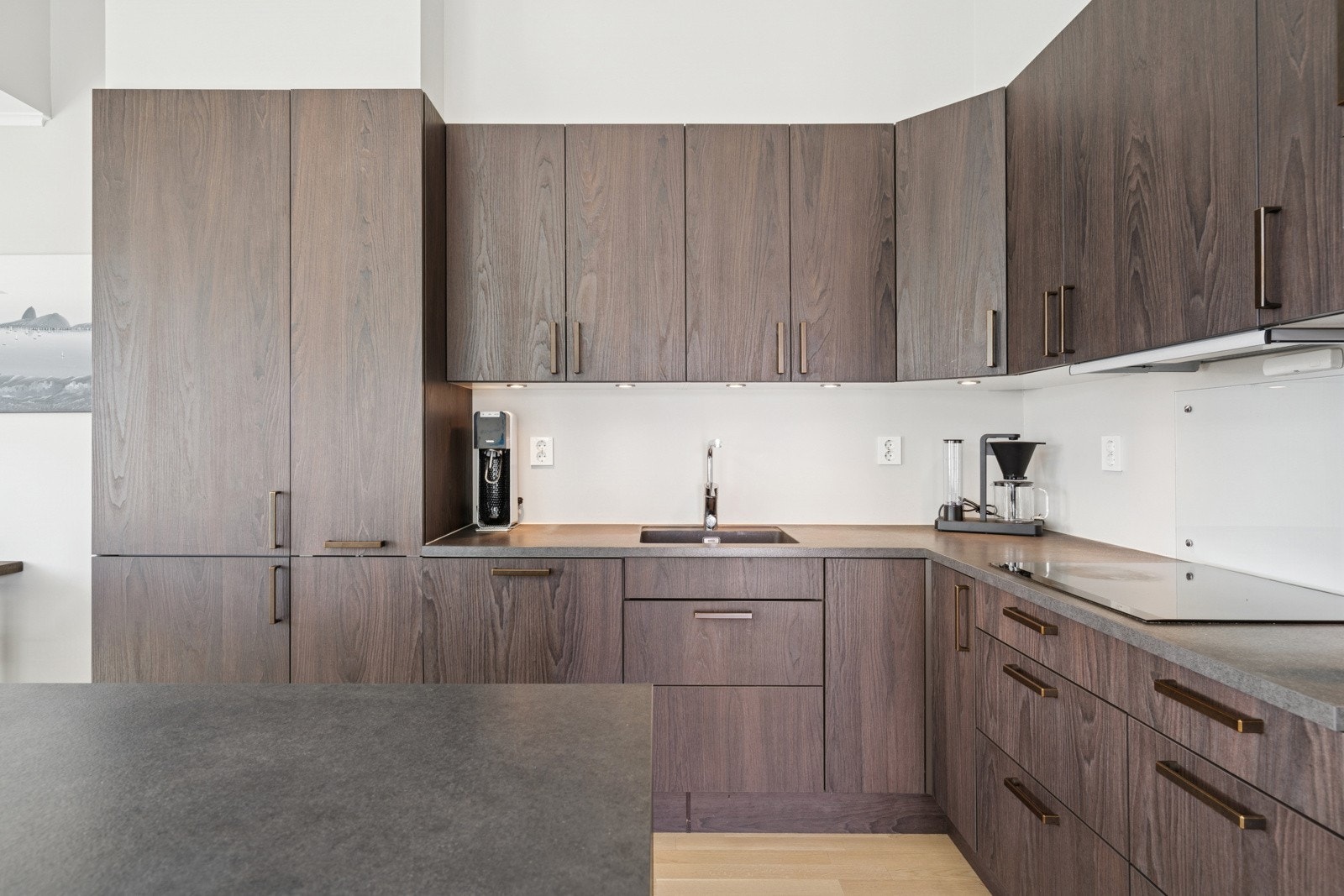 Kjøkkenet er innredet med glatte fronter og benkeplate av laminat. Avtrekket er via balansert ventilasjon. Galleribilde