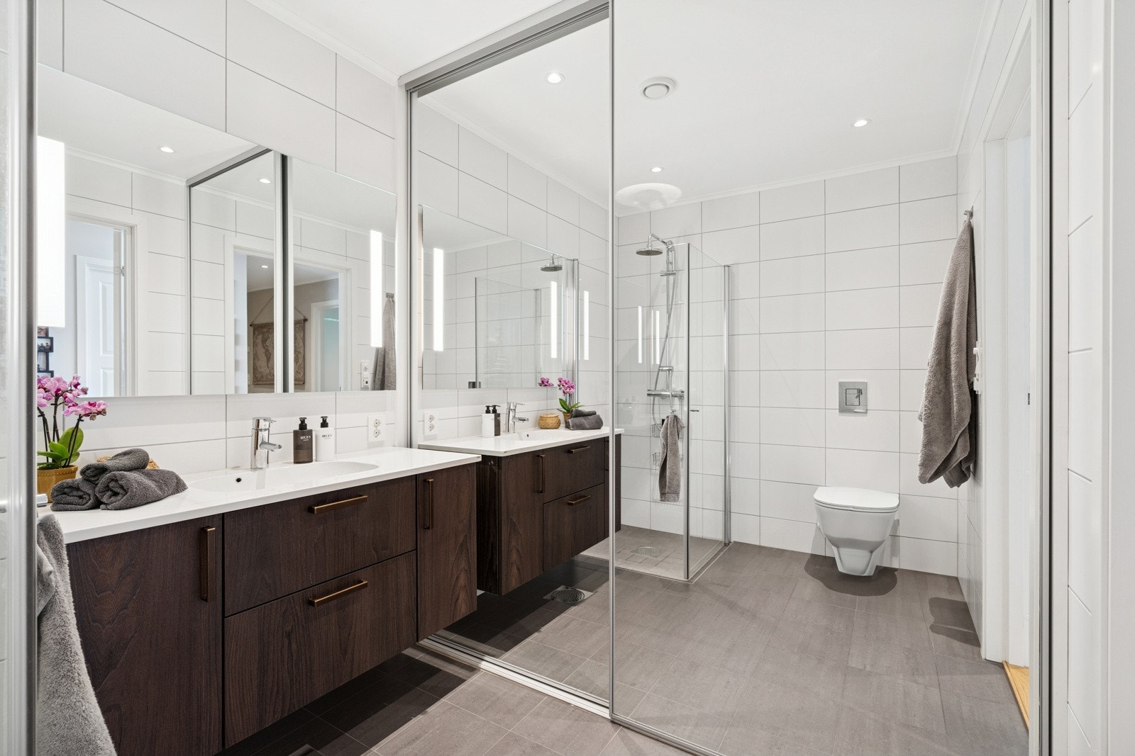 Rommet har innredning med nedfelt servan, veggmontert toalett og dusjvegger/hjørne. Galleribilde