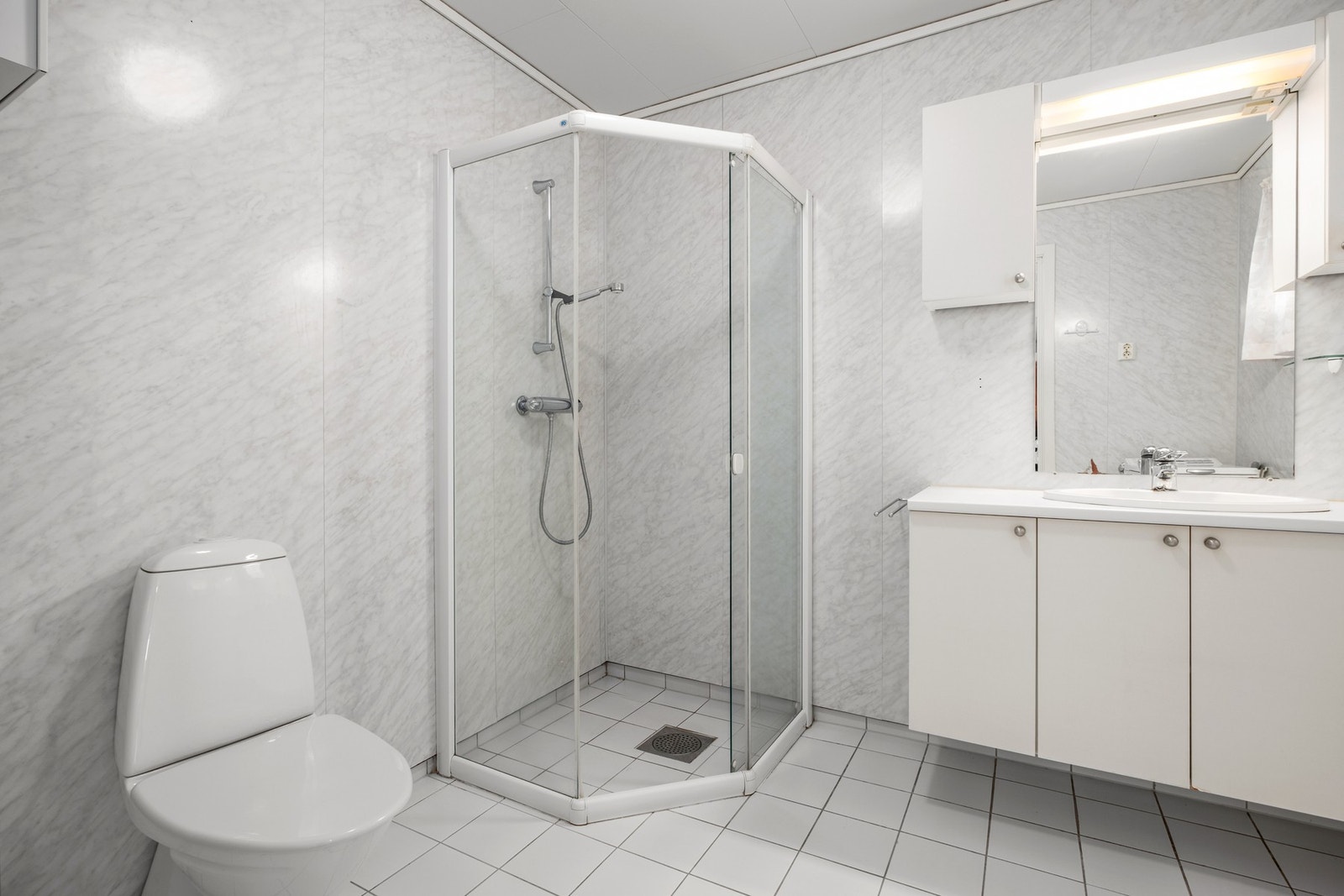 Badet er blant annet utstyrt med med mekanisk avtrekk, opplegg for vaskemaskin, servant, servantskap, wc og dusjhjørne. Galleribilde