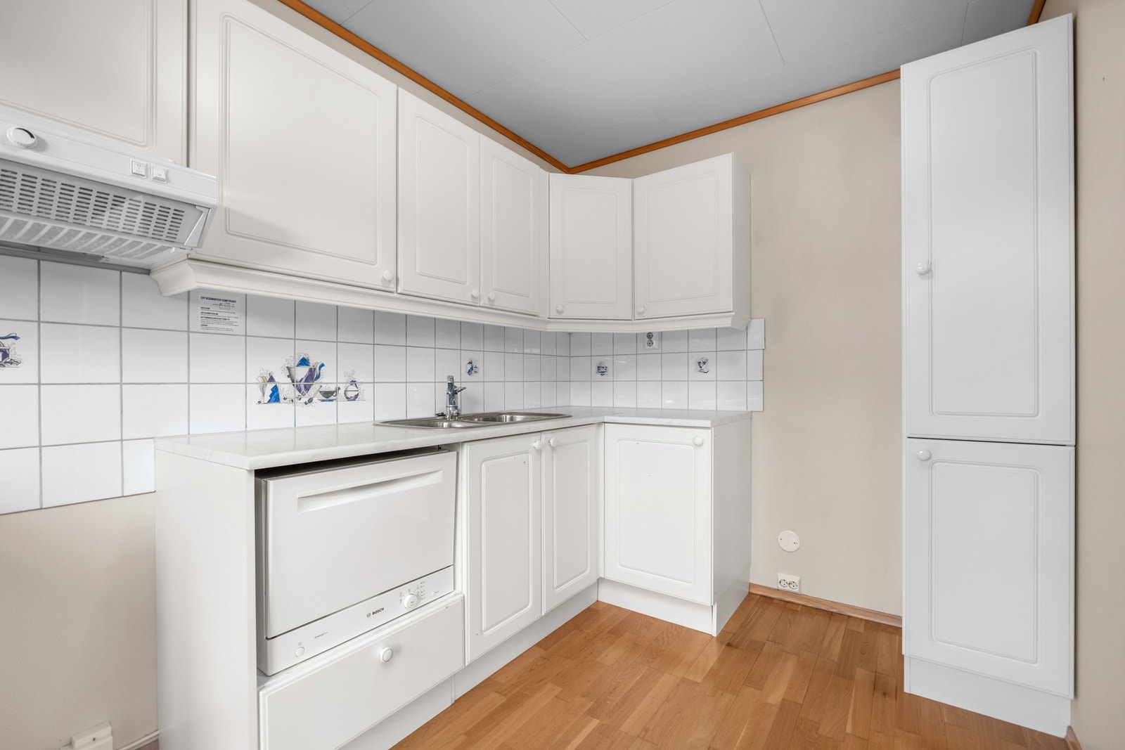 Hvit kjøkkeninnredning i klassisk utførelse med profilerte fronter. Galleribilde