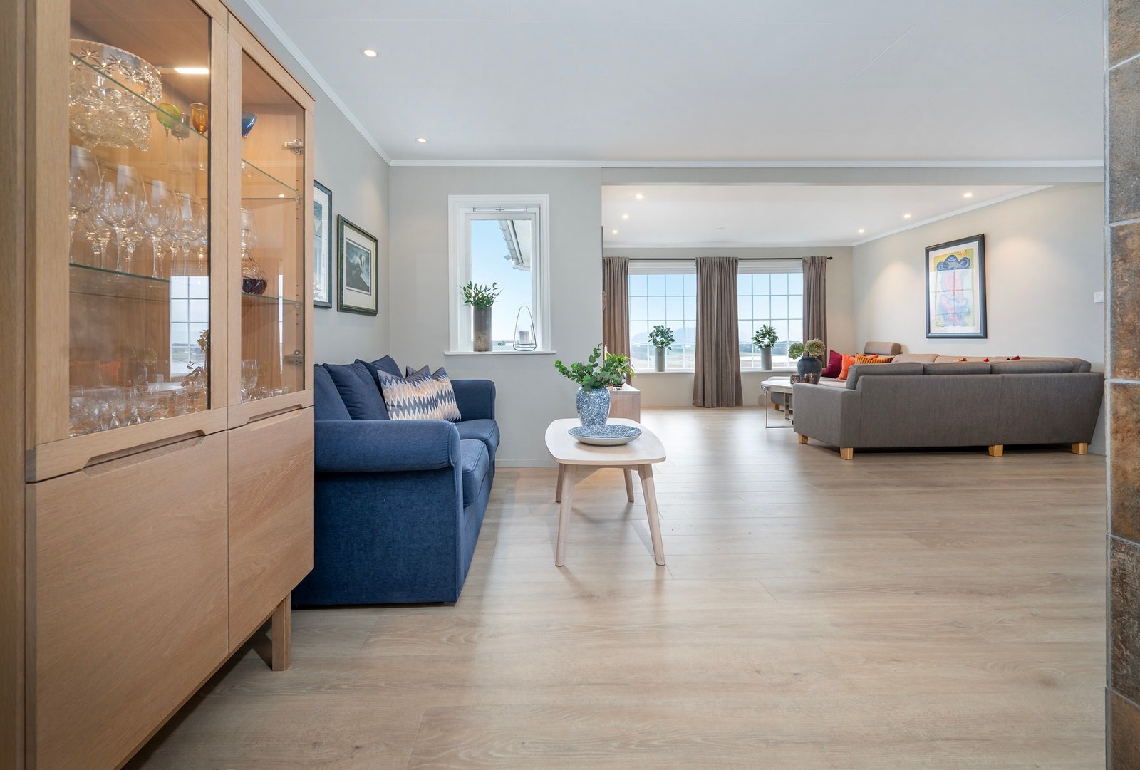 Stor og lys stue med flere soner. Galleribilde