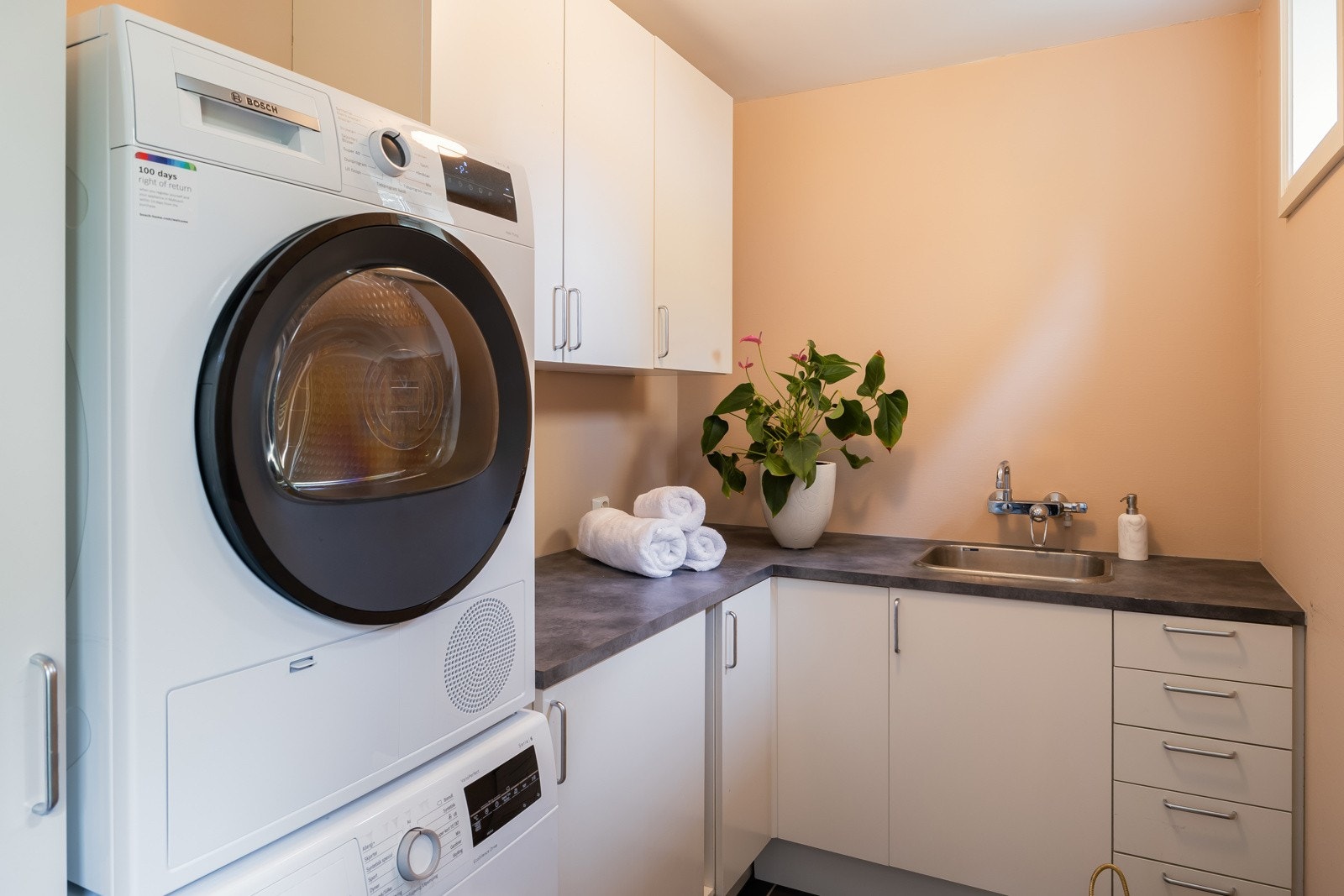 Praktisk vaskerom vegg i vegg med badet i hovedetasjen. For øvrig effektiv tilgang utenfra med terrassedør til baksida i gangen like ved. Galleribilde