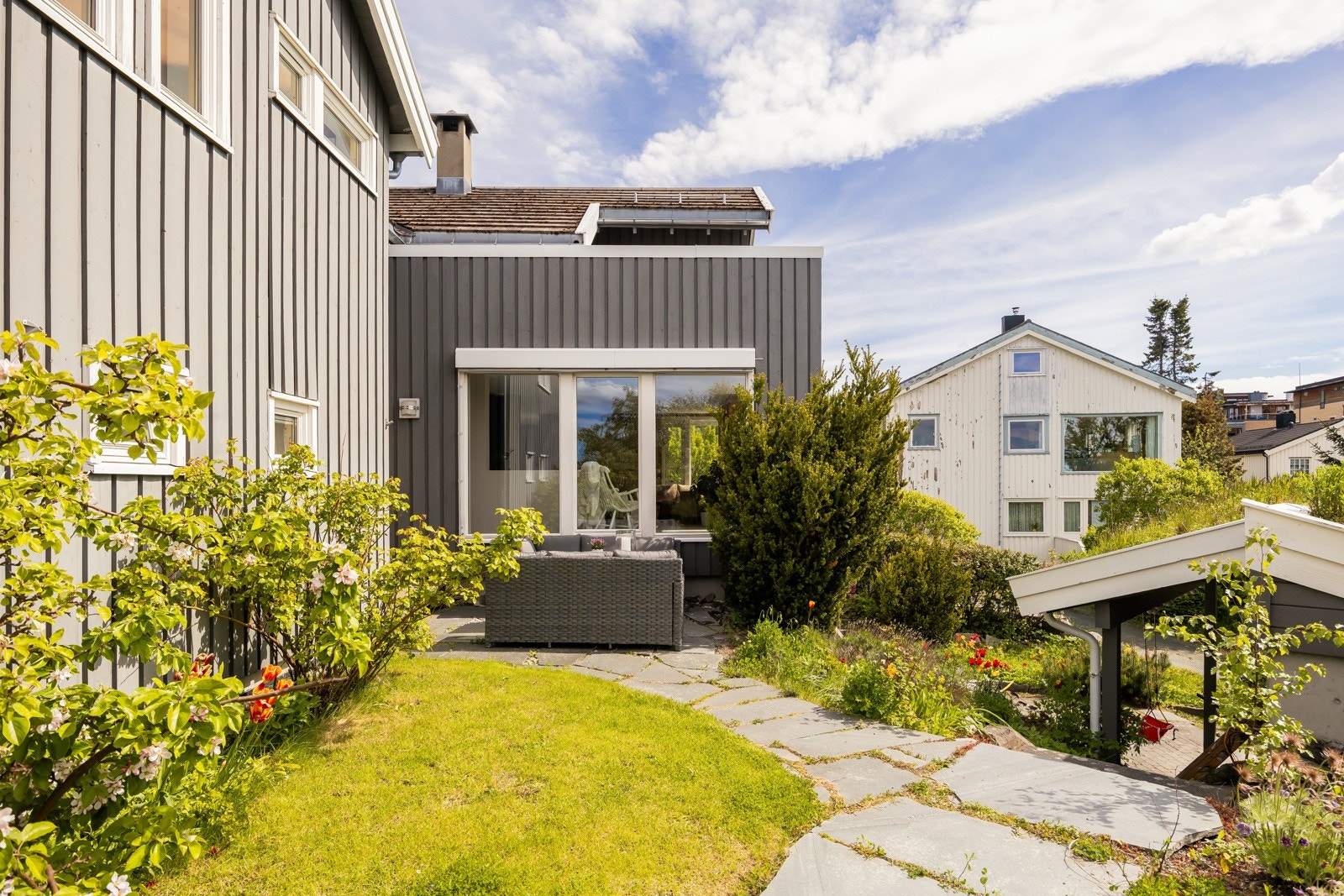 Den frodige hagen byr på frukttrær, bærbusker, helleganger og pent opparbeidede blomsterbed. Galleribilde