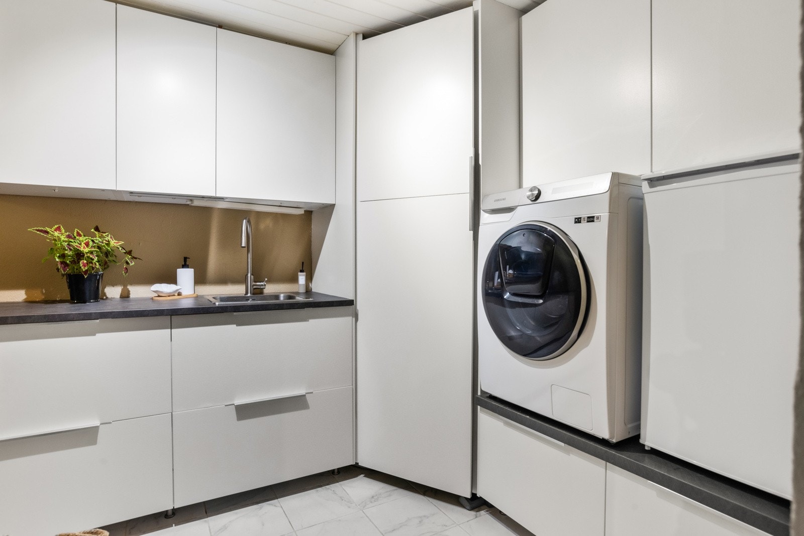 Vaskerommet er romslig og praktisk med skap for oppbevaring, flislagt gulv og malte vegger. (ikke godkjent som rom for varig opphold). Galleribilde