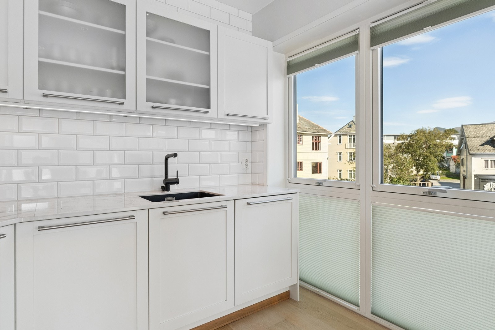 Nyare svart servant og armatur og kvite fliser på vegg gjev eit moderne uttrykk. Dei store vindauga slepp inn godt med arbeidslys Galleribilde