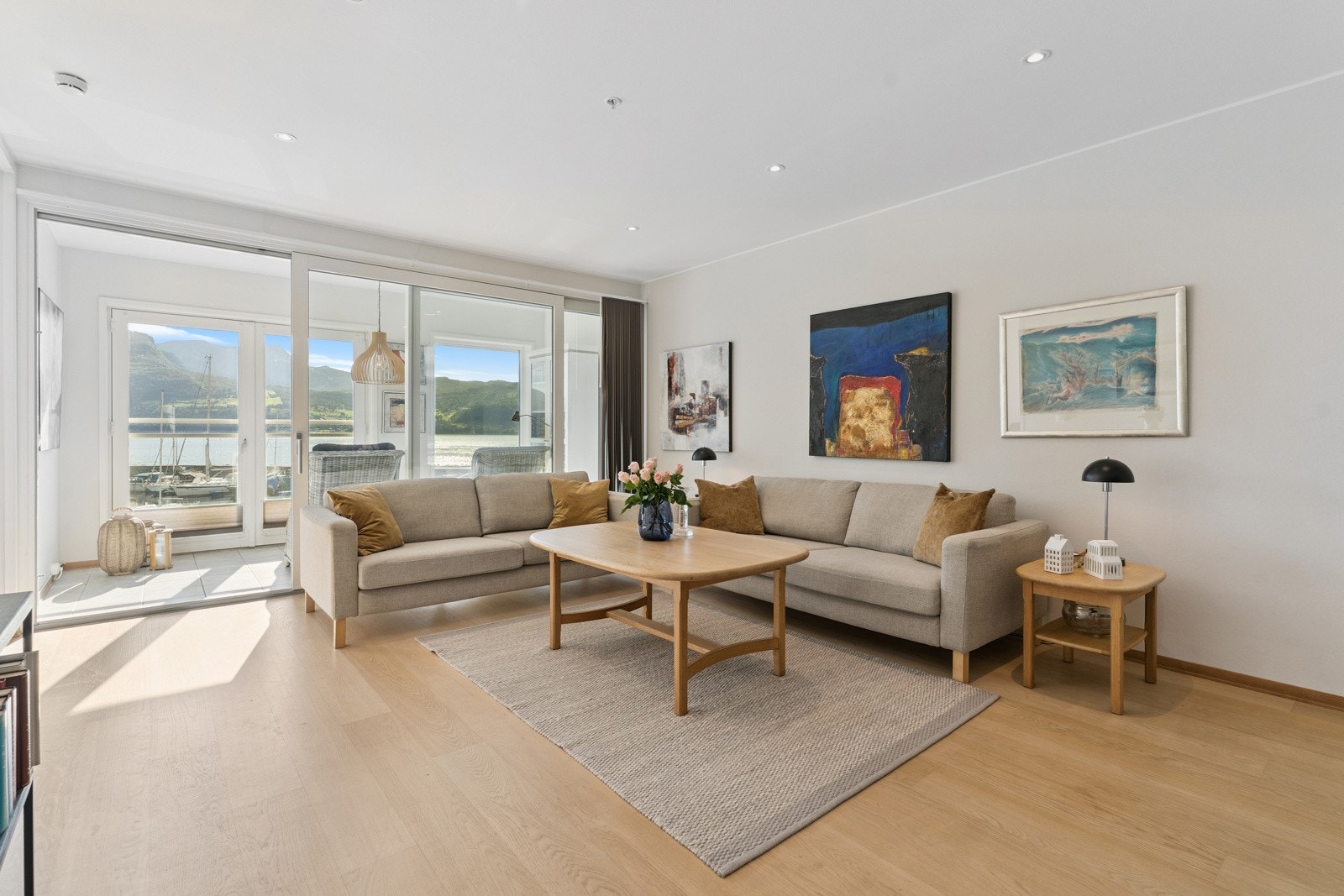 Tiltalande stove med lyse overflater og downlighsbelysning i himling. Store vindaugsflater gjev fint lysinnslepp og ei god romkjensle Galleribilde