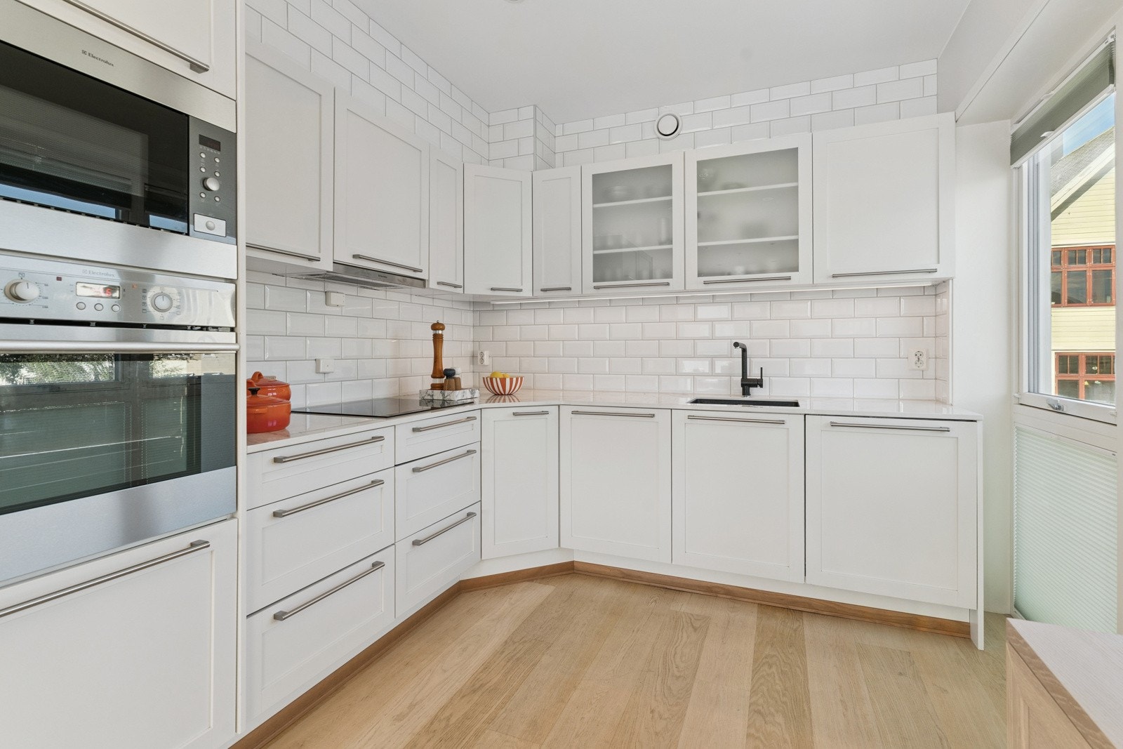 Flott lyst kjøkken med god skap-, skuffe- og benkeplass Galleribilde