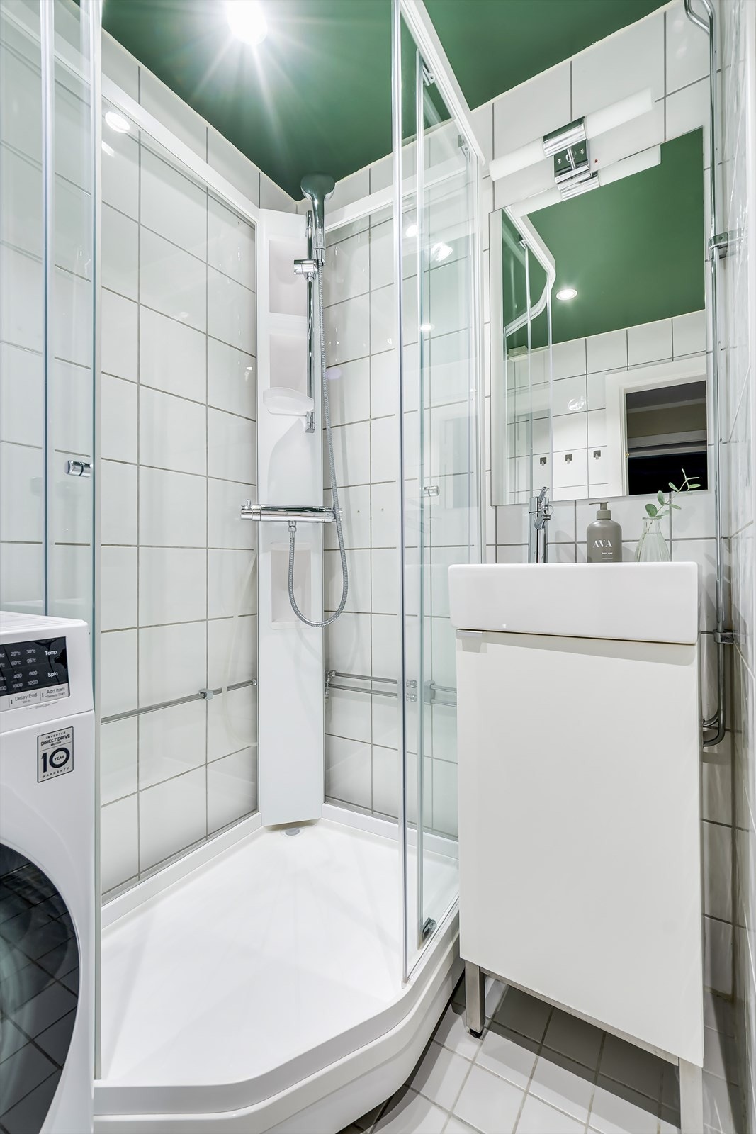 Badet er innredet med veggmontert toalett, dusjkabinett med herdet glass, servantinnredning og speil med overlys. Opplegg for vaskemaskin. Galleribilde