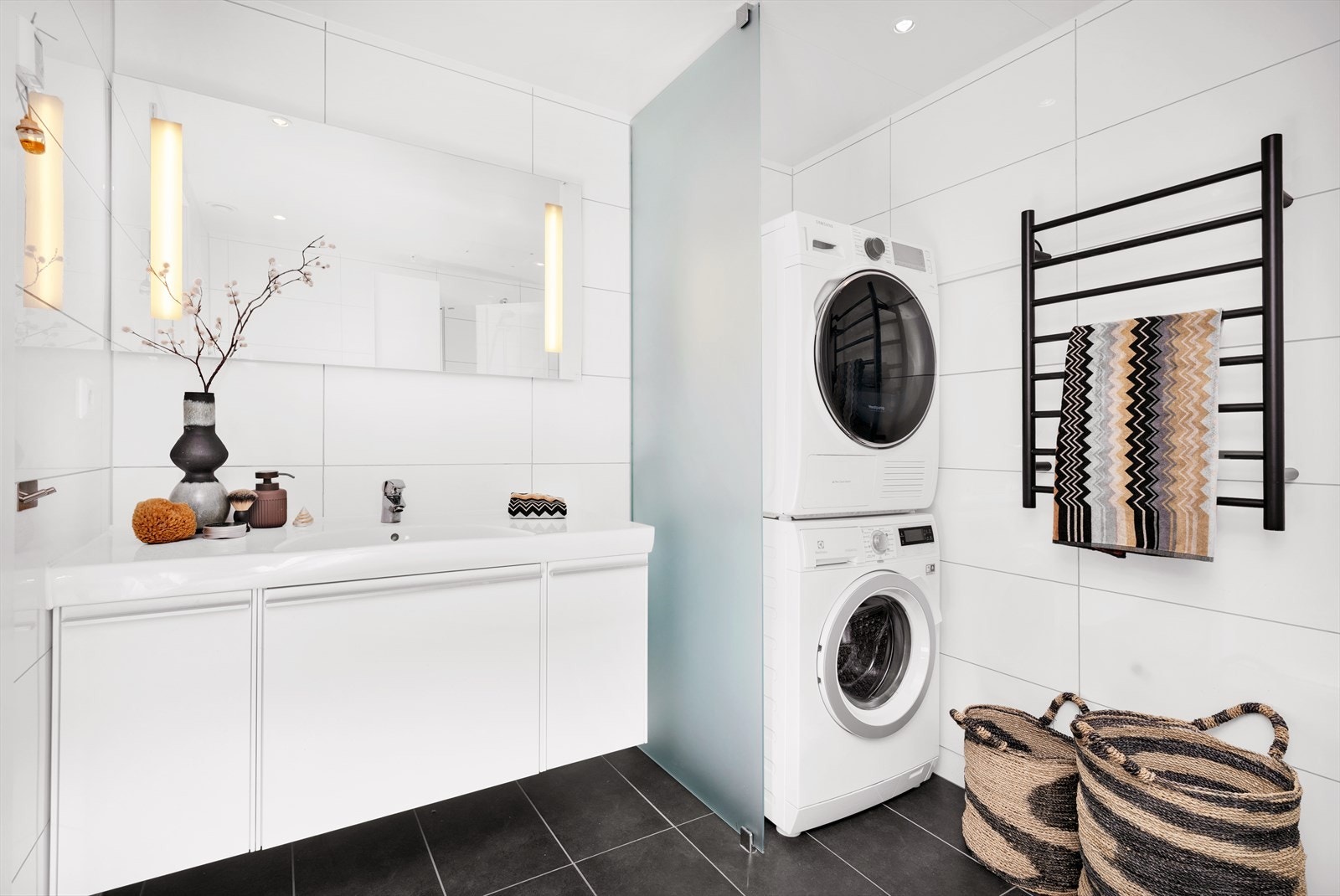 Leilighetens andre bad fremstår lyst og moderne med opplegg til vaskemaskin Galleribilde