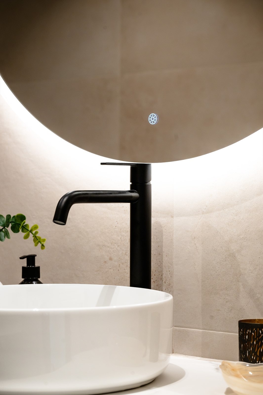 Detaljer som sort armatur og speil med integrert belysning understreker den gjennomførte stilen. Galleribilde