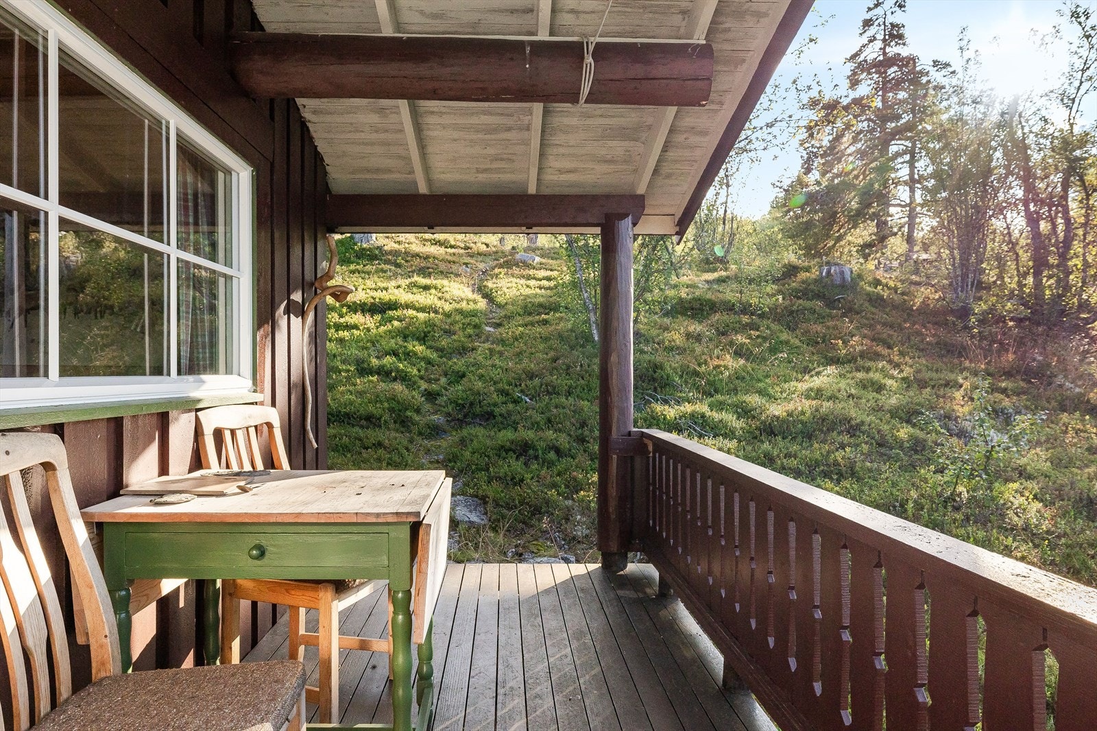 Verandaen har adkomst fra både terreng og stue, og stien som fører ned til hytta fra parkeringslommen kommer ned ved verandaen. Galleribilde