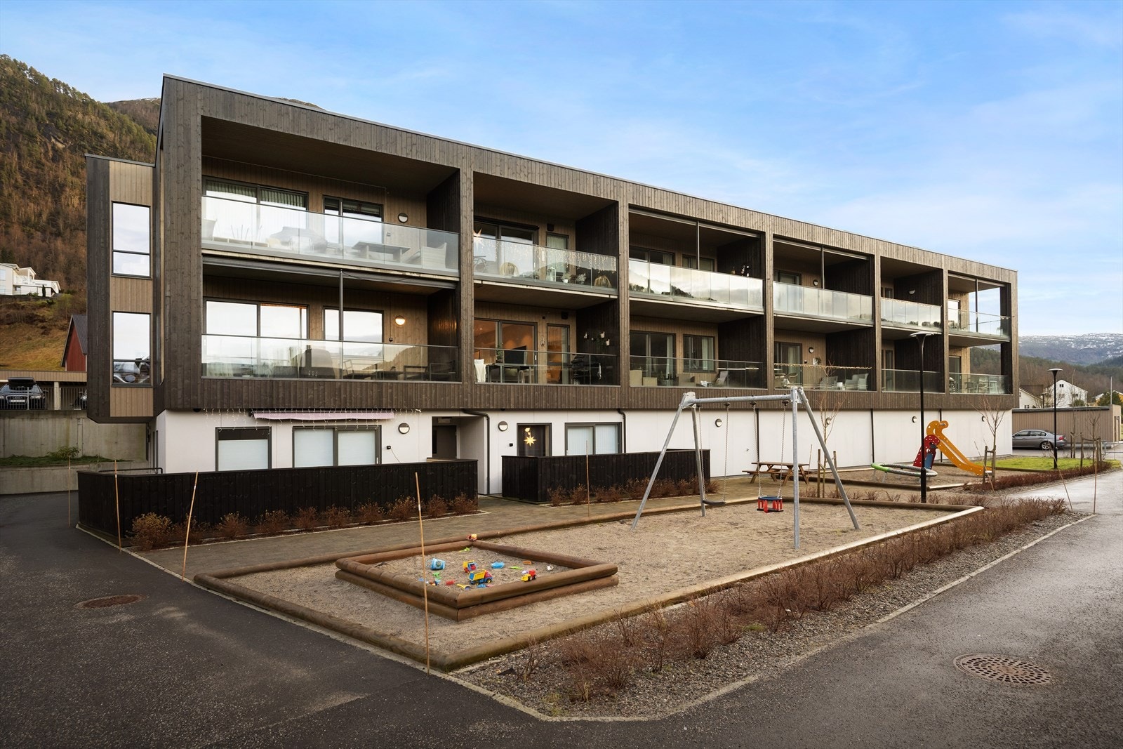 Lettstelt fellesareal med leikeplass og sitjebenkar Galleribilde