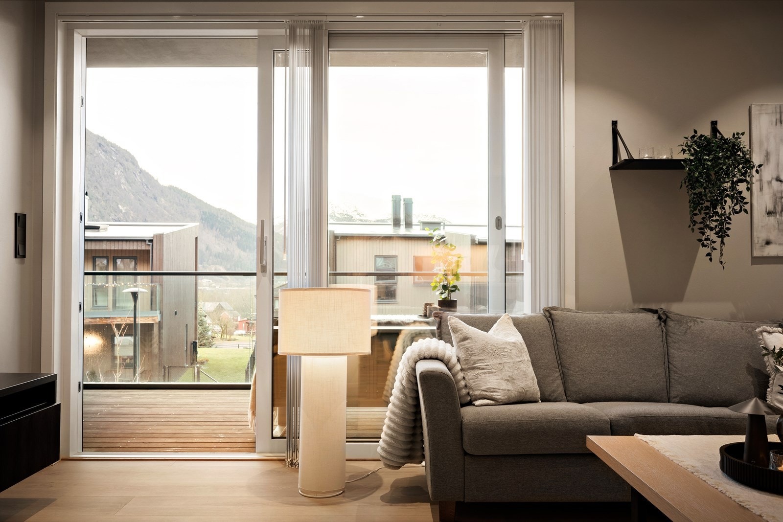 Golv-til-tak skyvedør slepp inn mykje naturleg dagslys mot vest og leiar ut til overbygd balkong Galleribilde