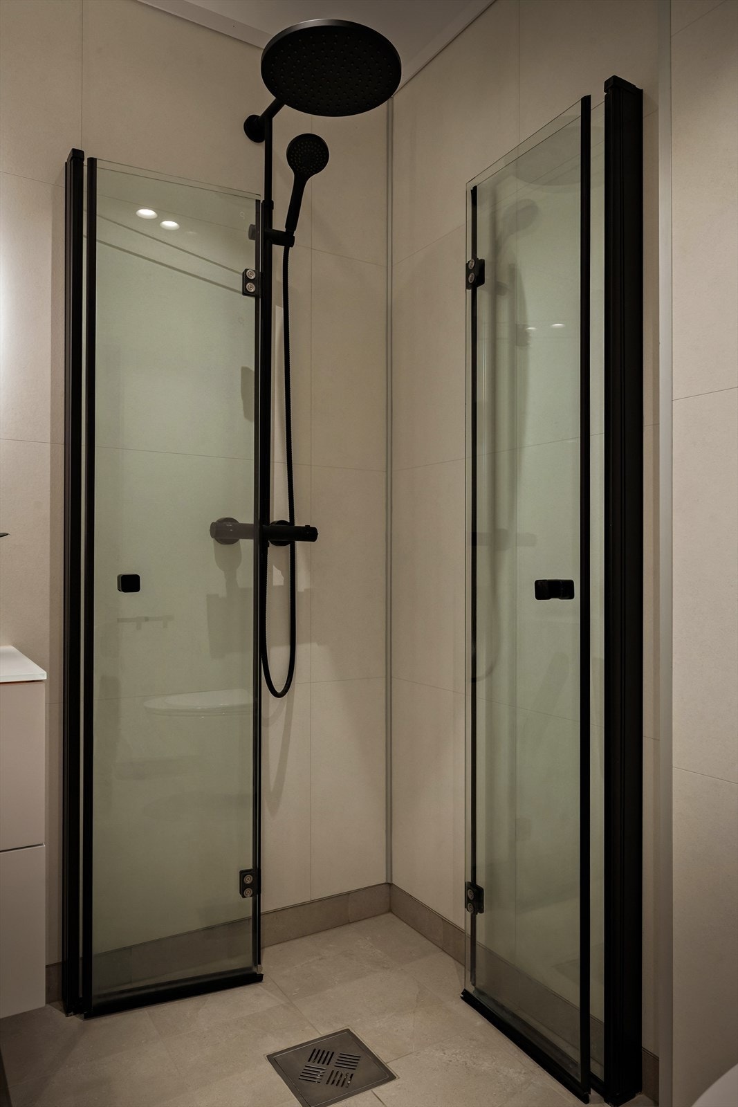 Foldeveggar i dusjhjørnet med svarte rammer med vegg, og takdusj Galleribilde