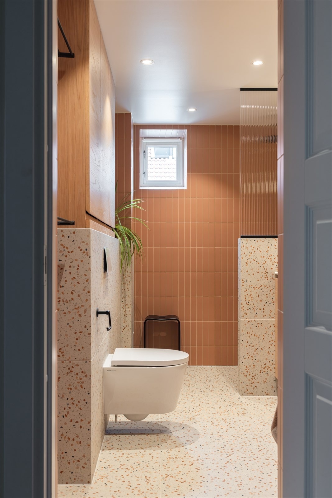 Et vindu slipper inn naturlig dagslys, mens harmoniske fargevalg og eksklusive materialer skaper en lun og innbydende atmosfære. Galleribilde