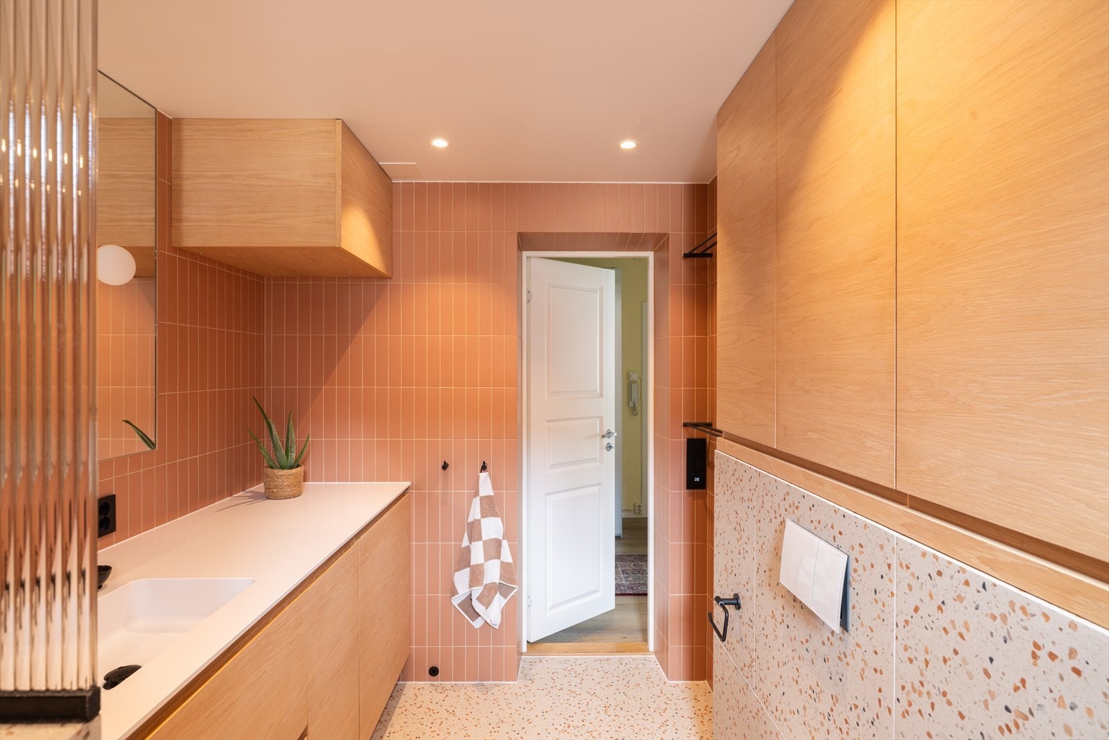 Badet byr på rikelig med oppbevaringsplass i plassbygde skap som matcher baderomsinnredningen og gir et helhetlig og ryddig uttrykk. Galleribilde