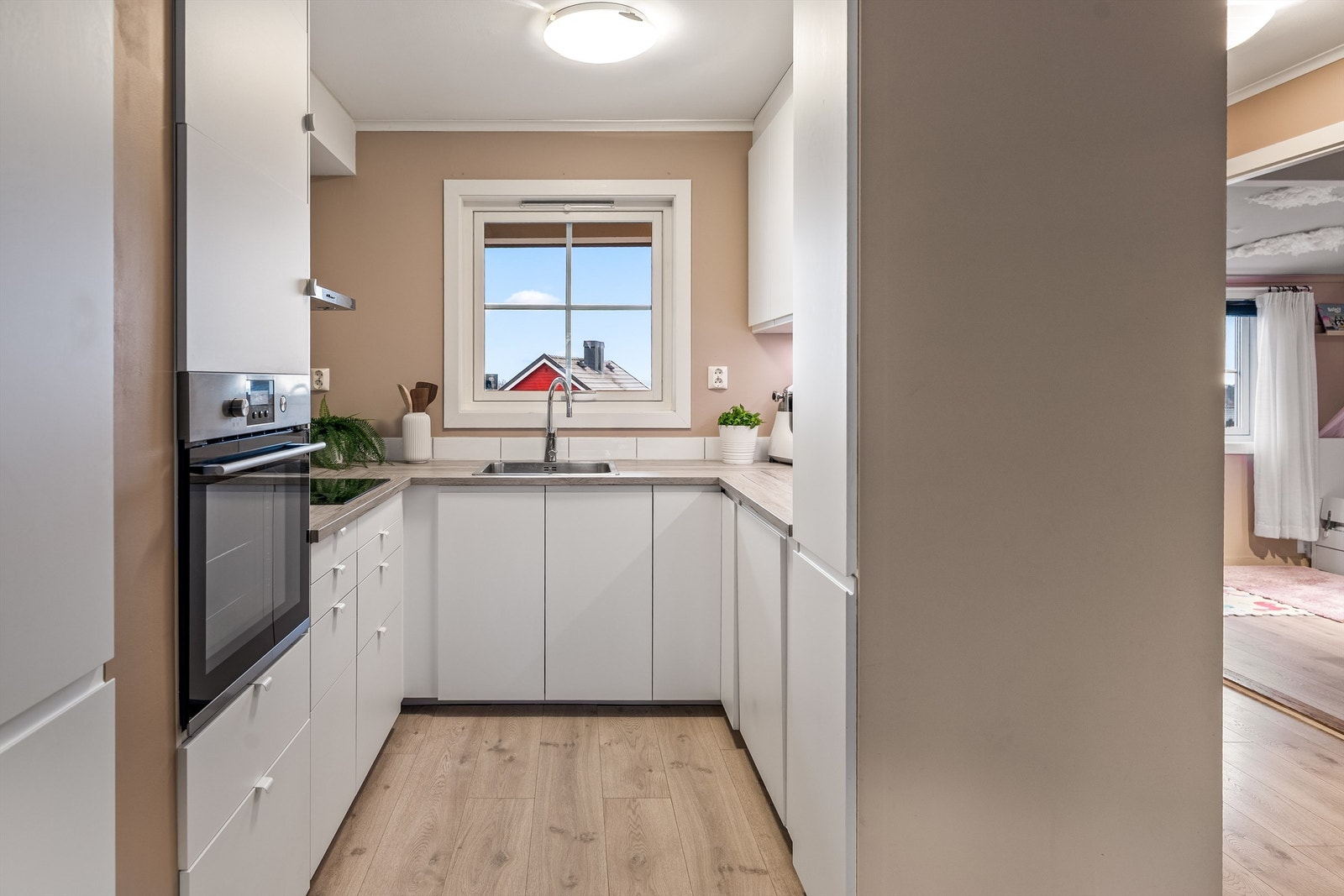 Kjøkken med integrerte hvitevarer og vegghengt komfyr Galleribilde