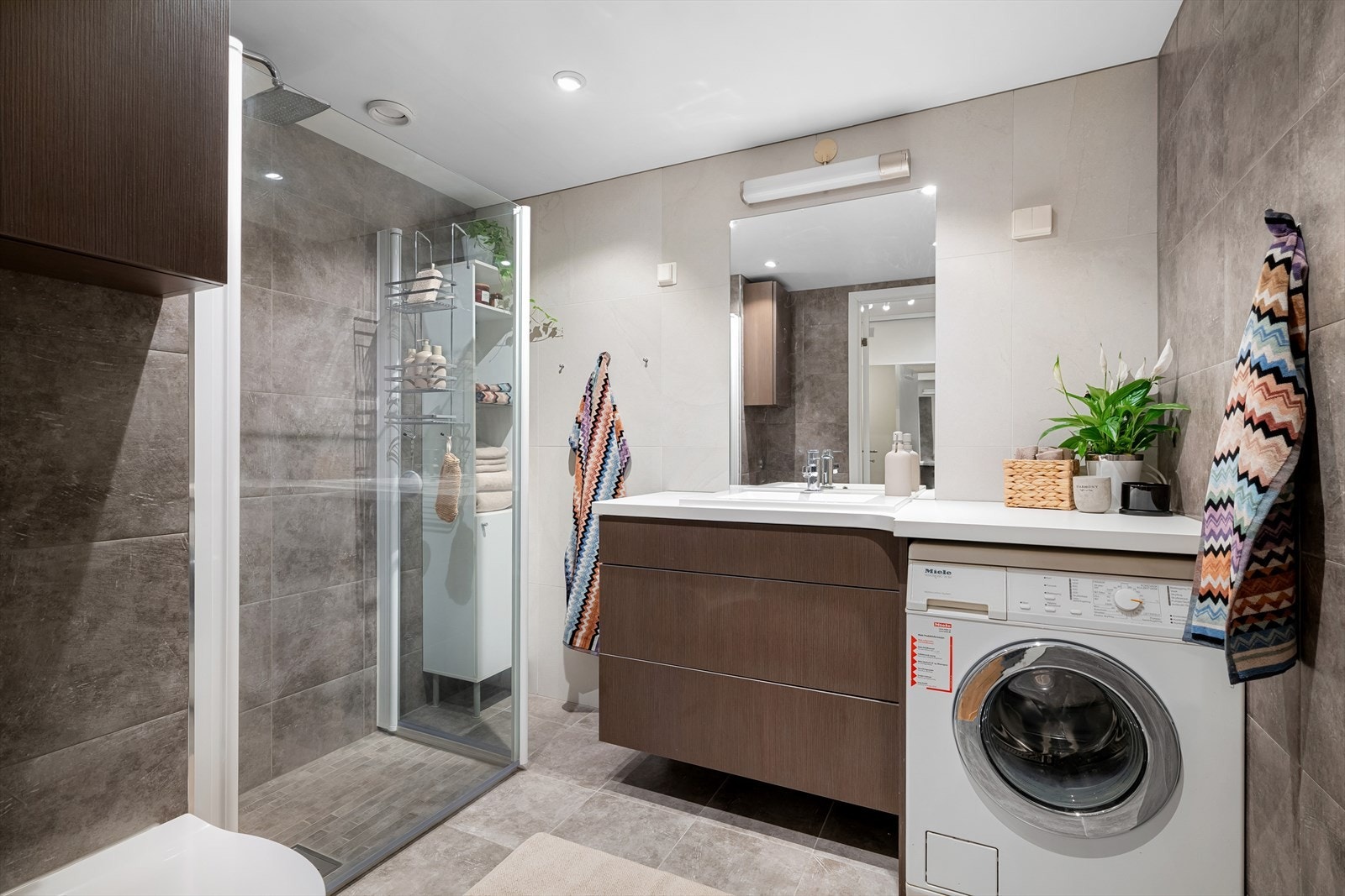 Baderomsinnredningen er stilren og moderne med ekstra lang benkeplate. Vaskemaskinen medfølger. Det er varme i gulvet. V.vann er inkludert i husleien og sørger derfor for lavere strømutgifter. Galleribilde