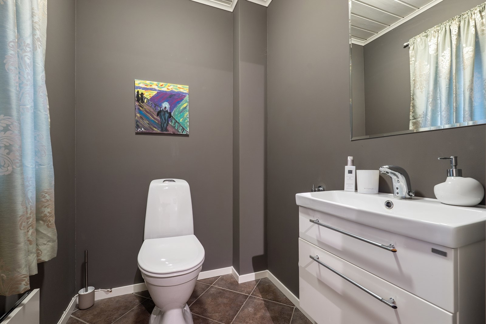 Praktisk toalettrom ved entrèen/hallen i 1. etasje. Det er belegg på gulv, malte overflater på vegg og panel i himling. Rommet har toalett og servantskap. Galleribilde