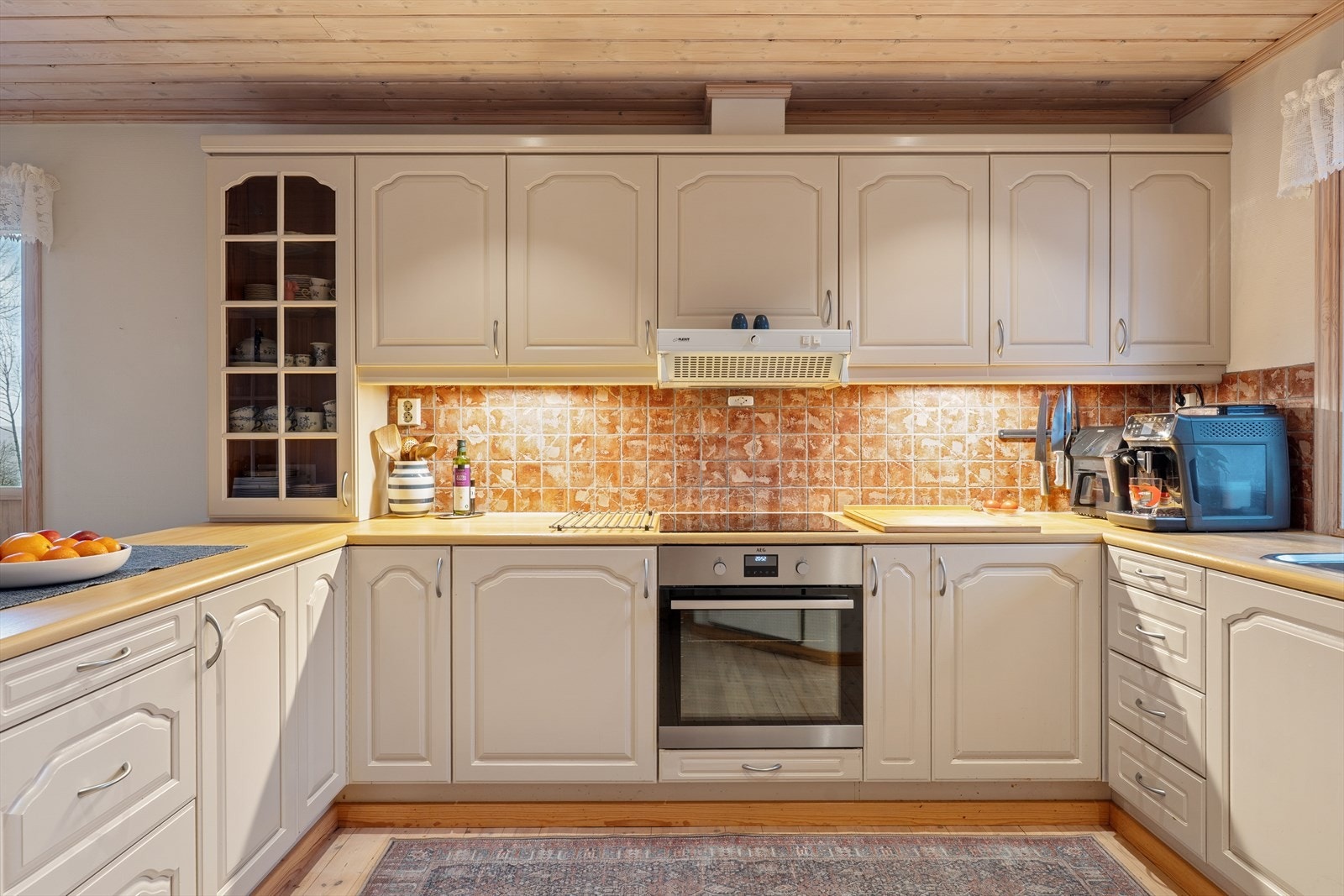 Kjøkkenet har tregulv, malte overflater på vegg og malte plater med downlights i himling. Galleribilde