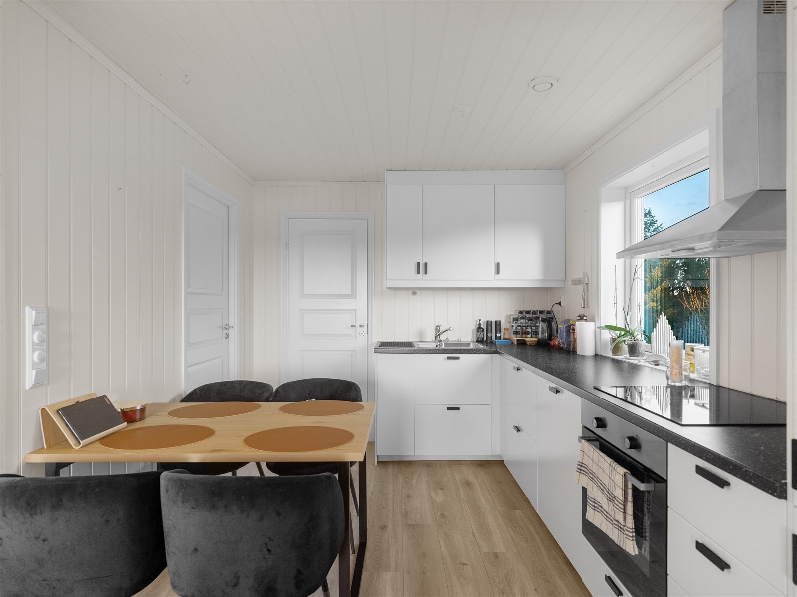 Lyst og innbydende kjøkken med integrerte hvitevarer Galleribilde