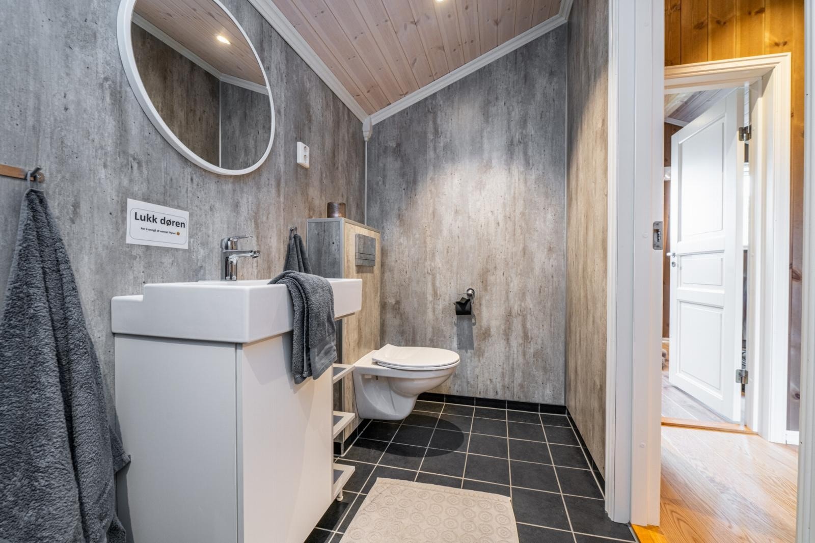 Bad med vegghengt toalett, servant og dusjsone. Galleribilde