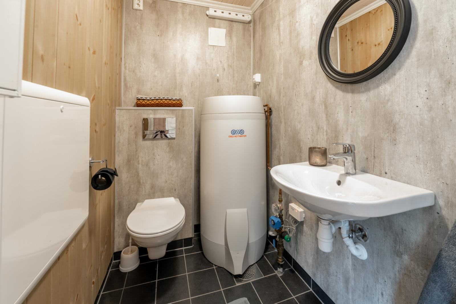 Praktisk toalettrom med servant, varmtvannsbereder og vindu. Galleribilde