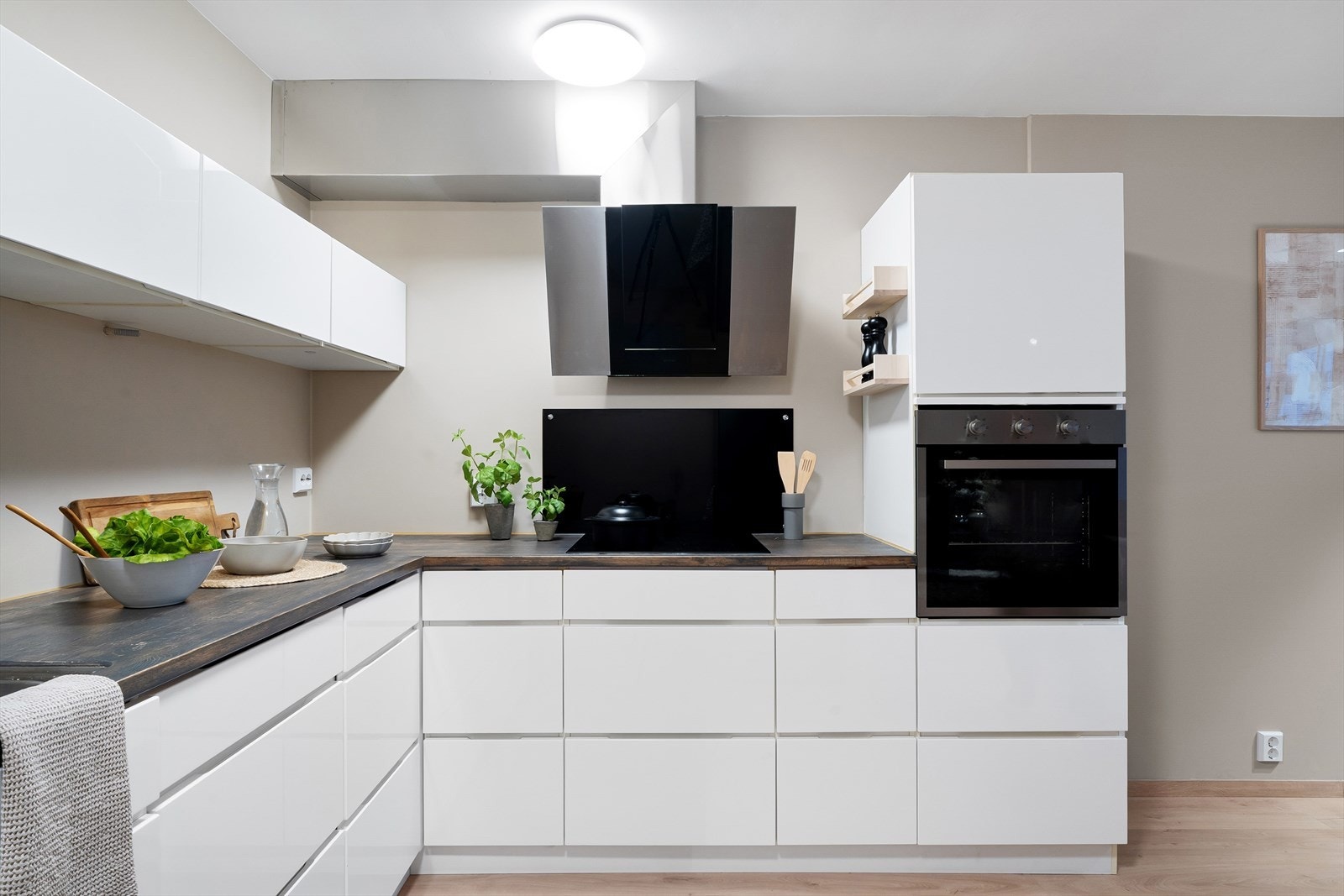 Hvit, moderne kjøkkeninnredning med god skap- og benkeplassø. Integrert stekeovn, induksjonstopp og oppvaskmaskin. Galleribilde