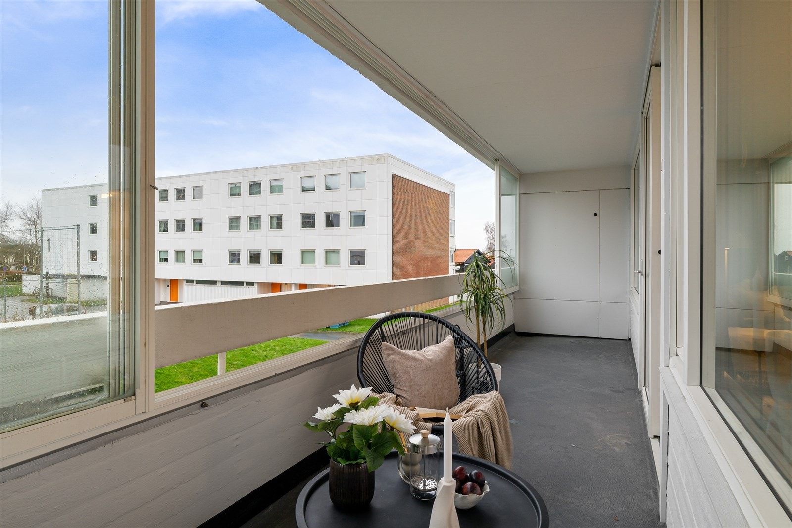 Innglasset balkong mot sør. På balkongen kan en åpne opp glassfeltene etter vær og vind. Leiligheten vil få ny og større balkong som etter planen vil være klar i løpet av 2026. Galleribilde