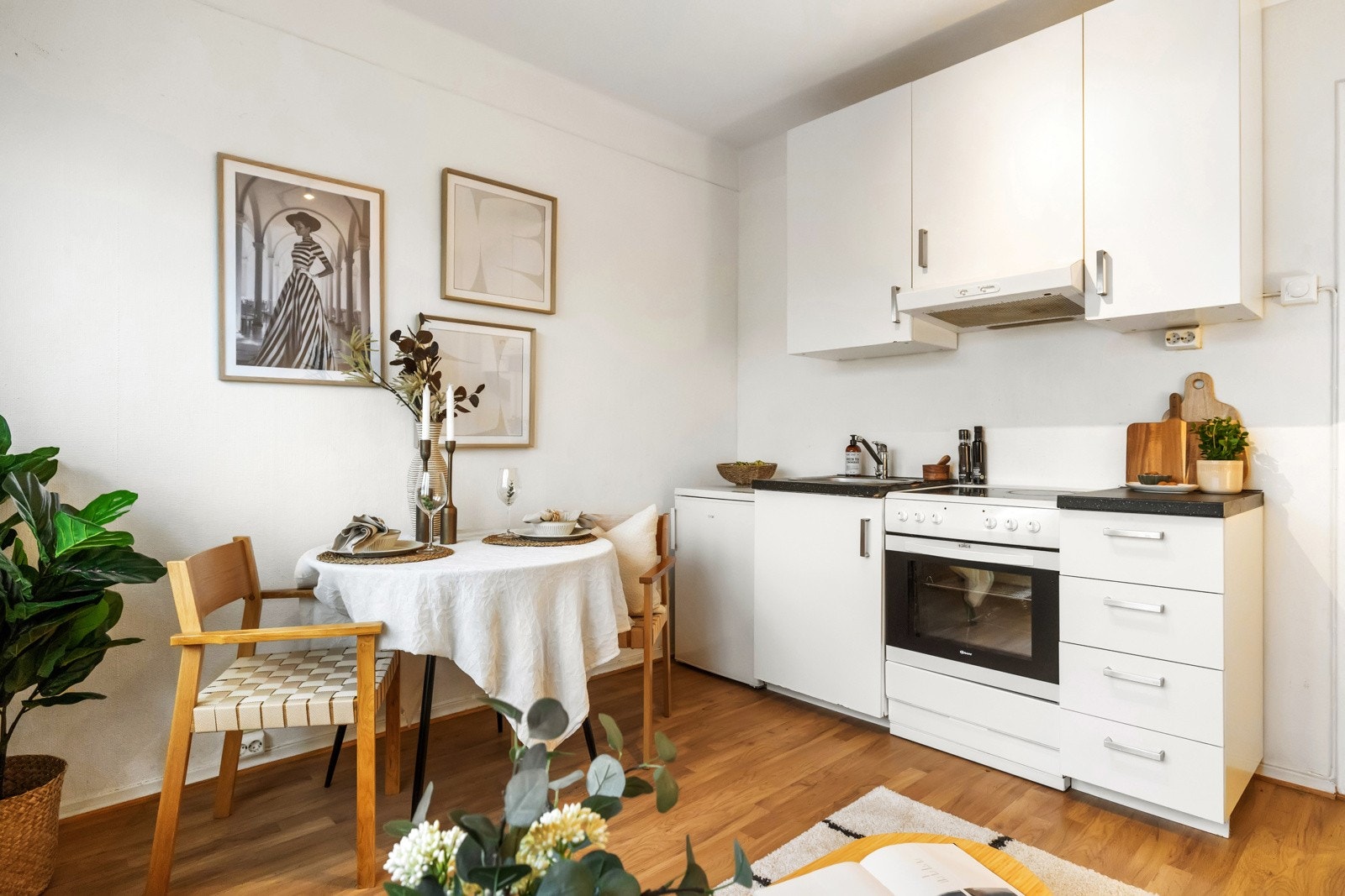 Kjøkkeninnredningen har glatte, hvite fronter og laminat benkeplate Galleribilde