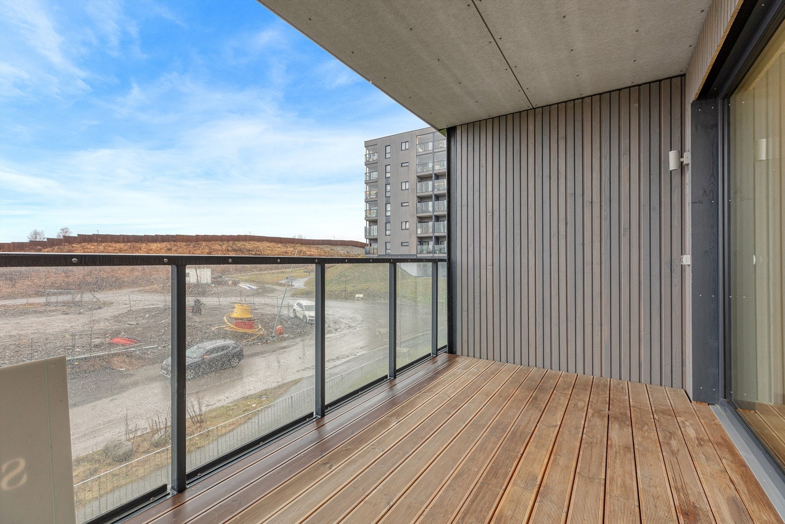 Uteplassen har gulv belagt med terrassebord og rekkverk i metall og glass. Galleribilde