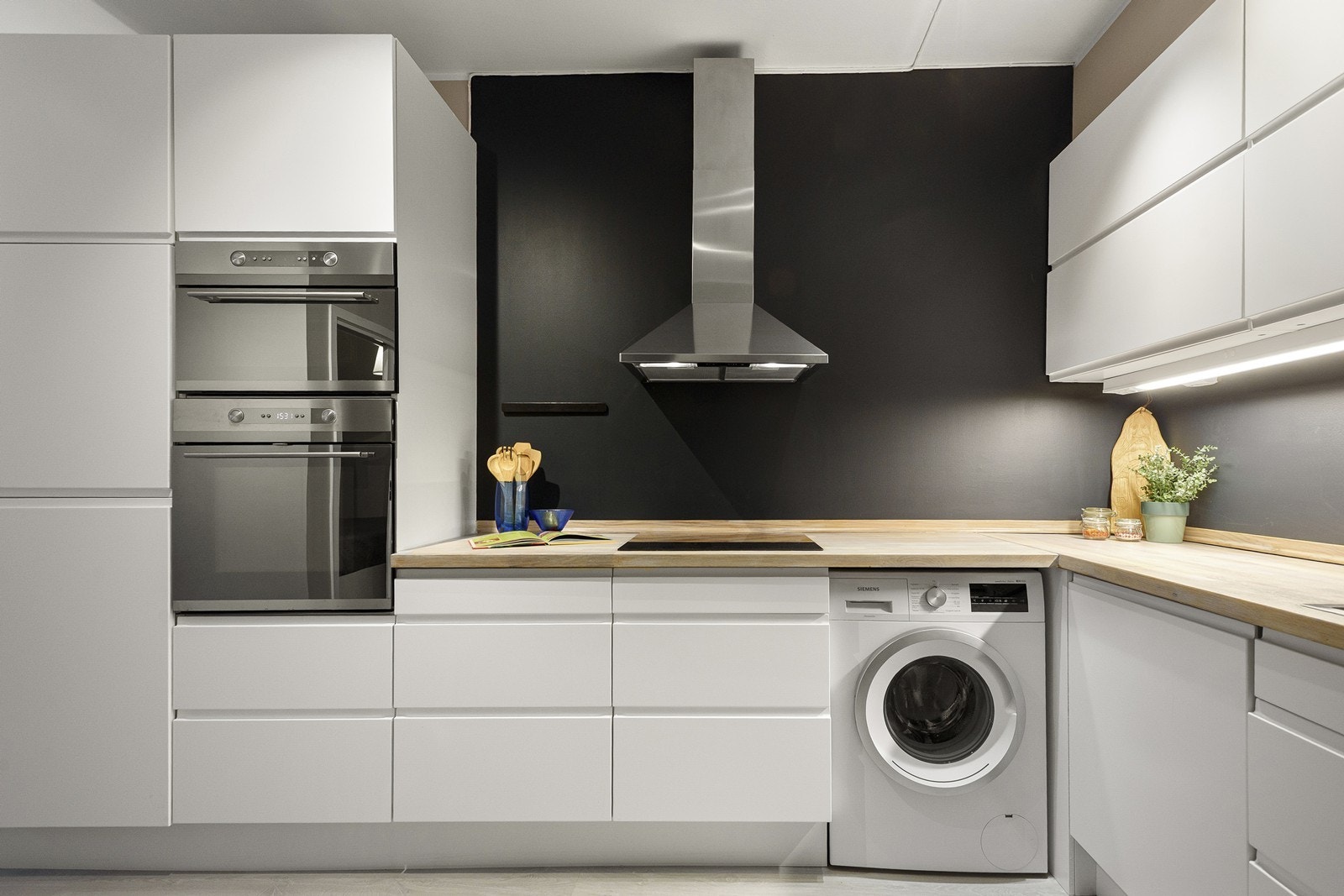 Kjøkkenet har integrert kjøl/fryseskap, stekeovn, platetopp og mikroovn, samt en pusset og oljet benkeplate (desember 2025) Galleribilde